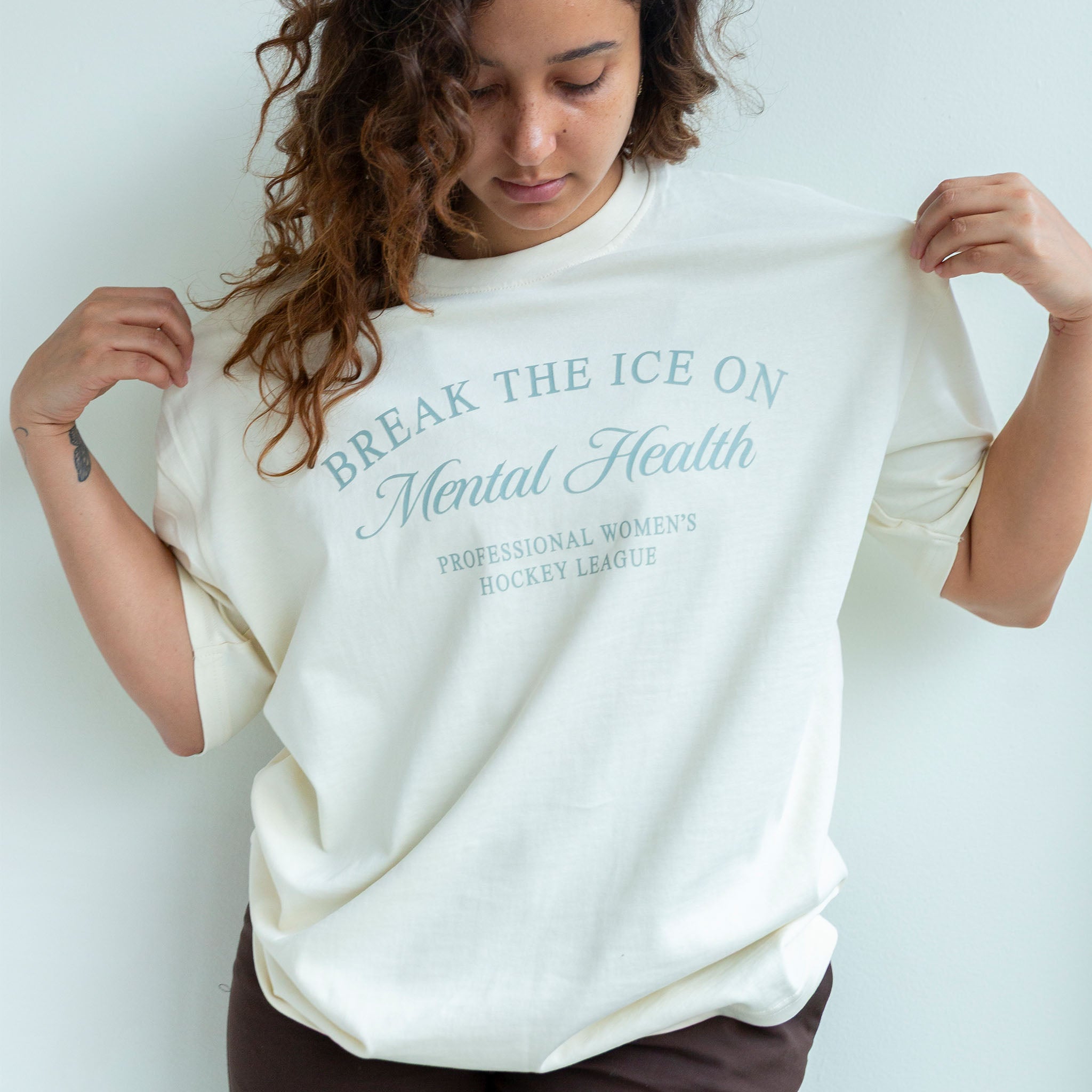 Person wearing a white sweatshirt with text about mental health awareness on a plain background