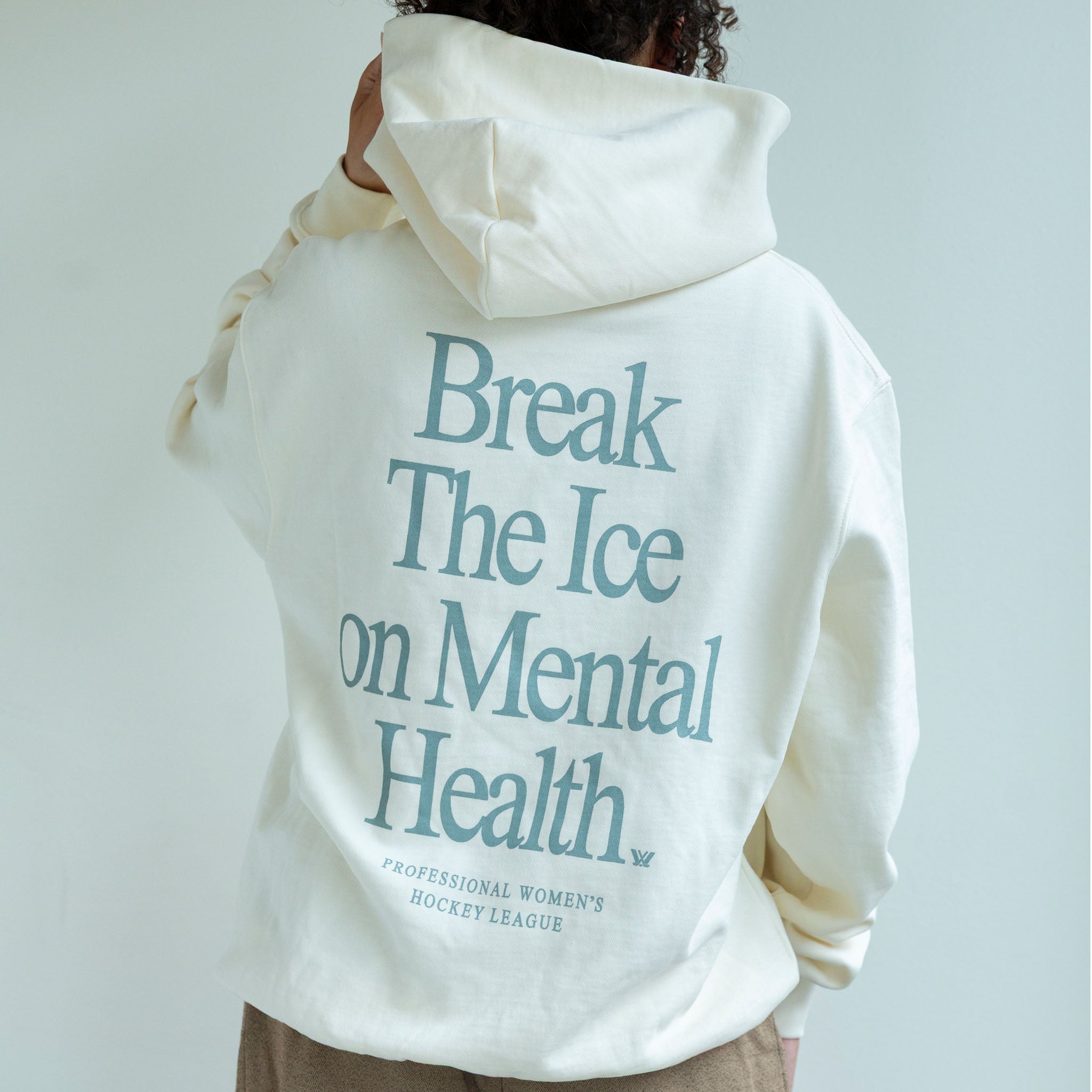 White hoodie with 'Break The Ice on Mental Health' text on the back, worn by a person.