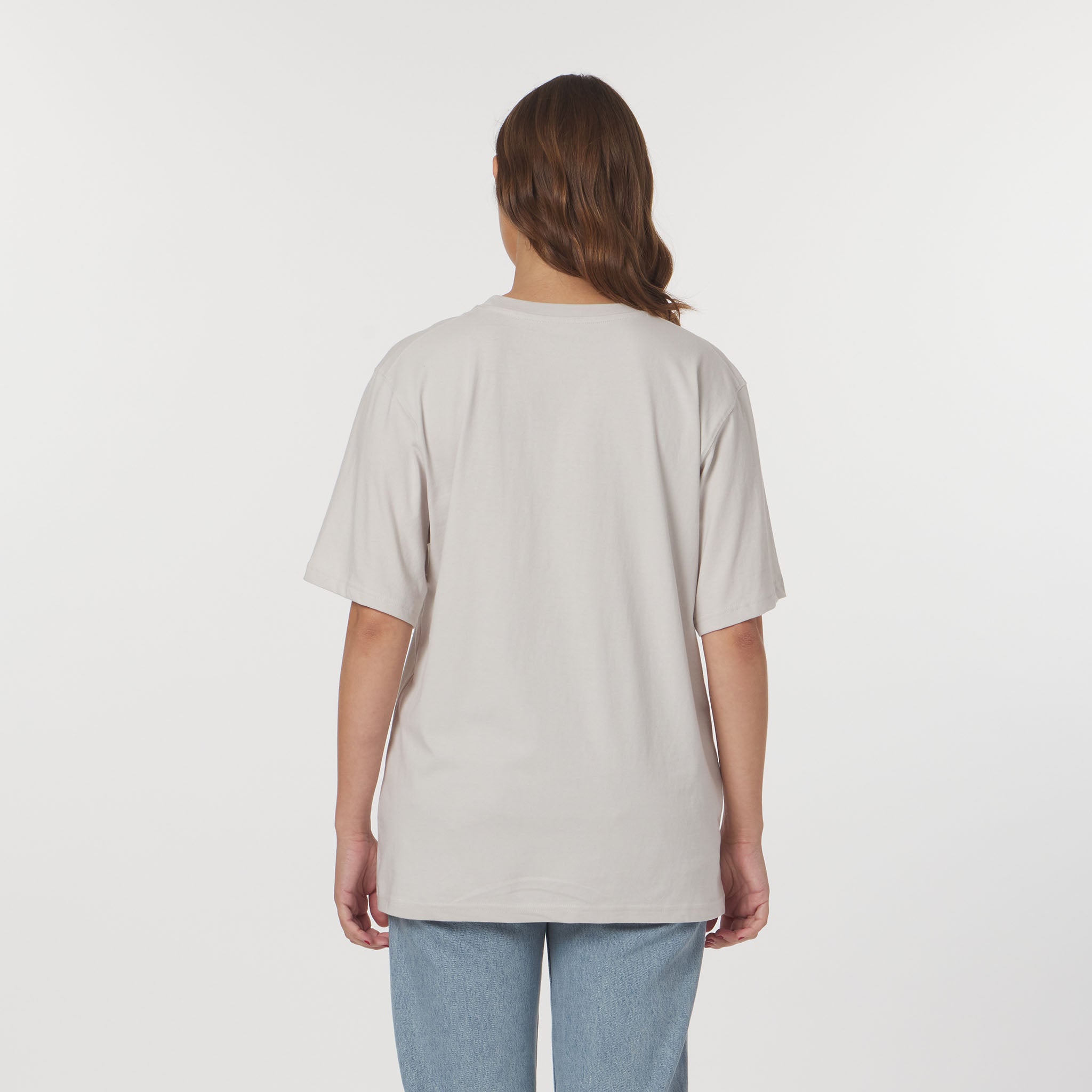 Person wearing a light gray t-shirt and blue jeans on a white background