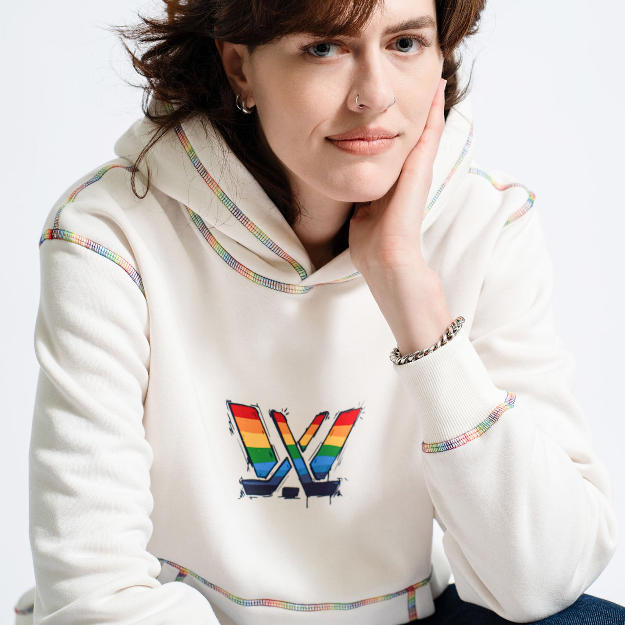 Person wearing a white hoodie with a colorful logo on a white background