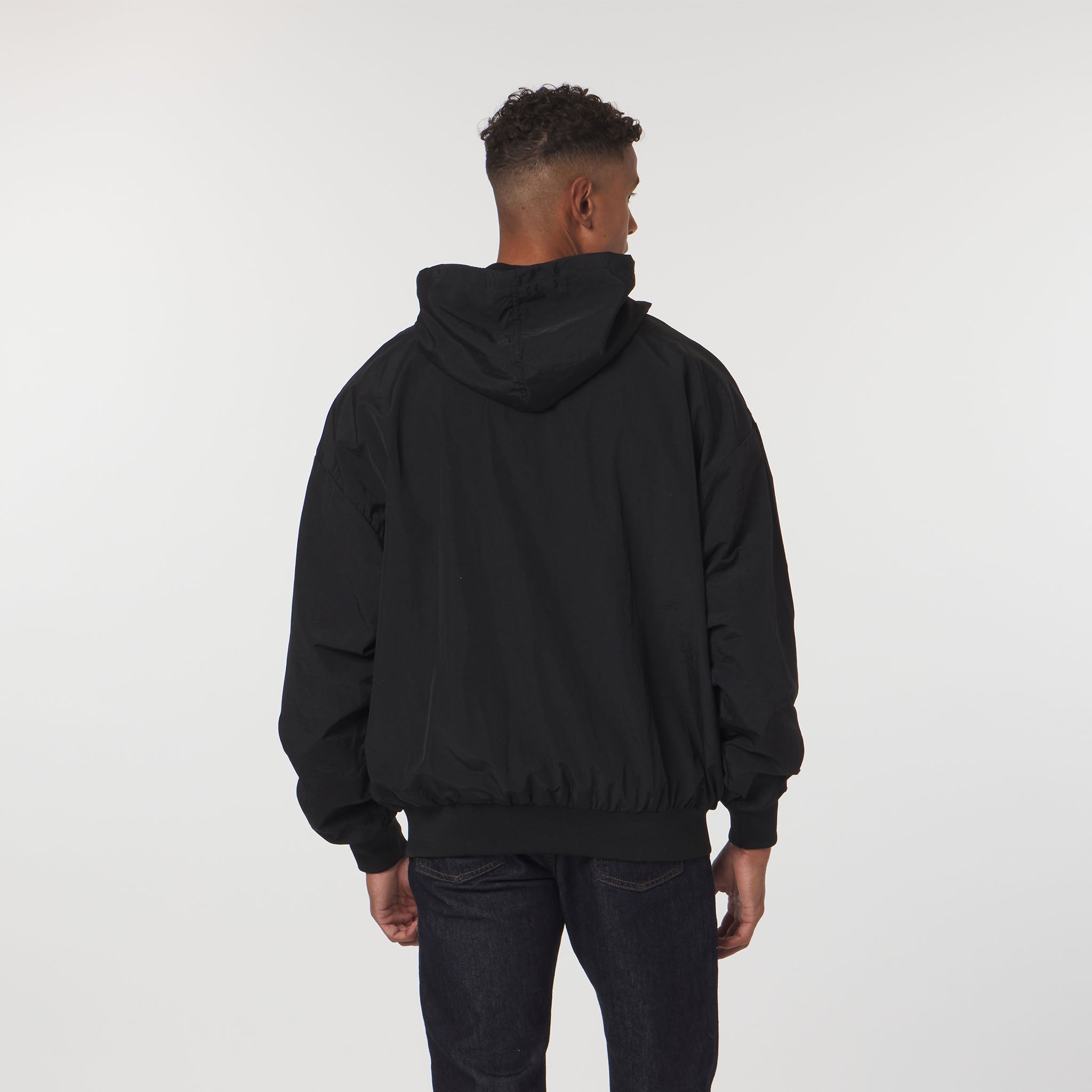 Person wearing a black hoodie from behind on a white background