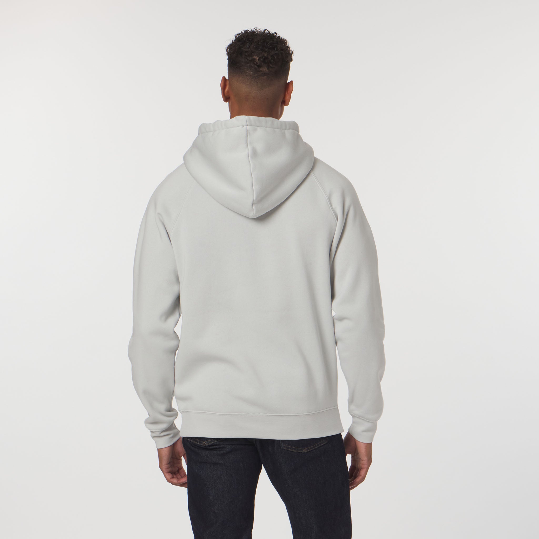 Person wearing a light gray hoodie on a white background