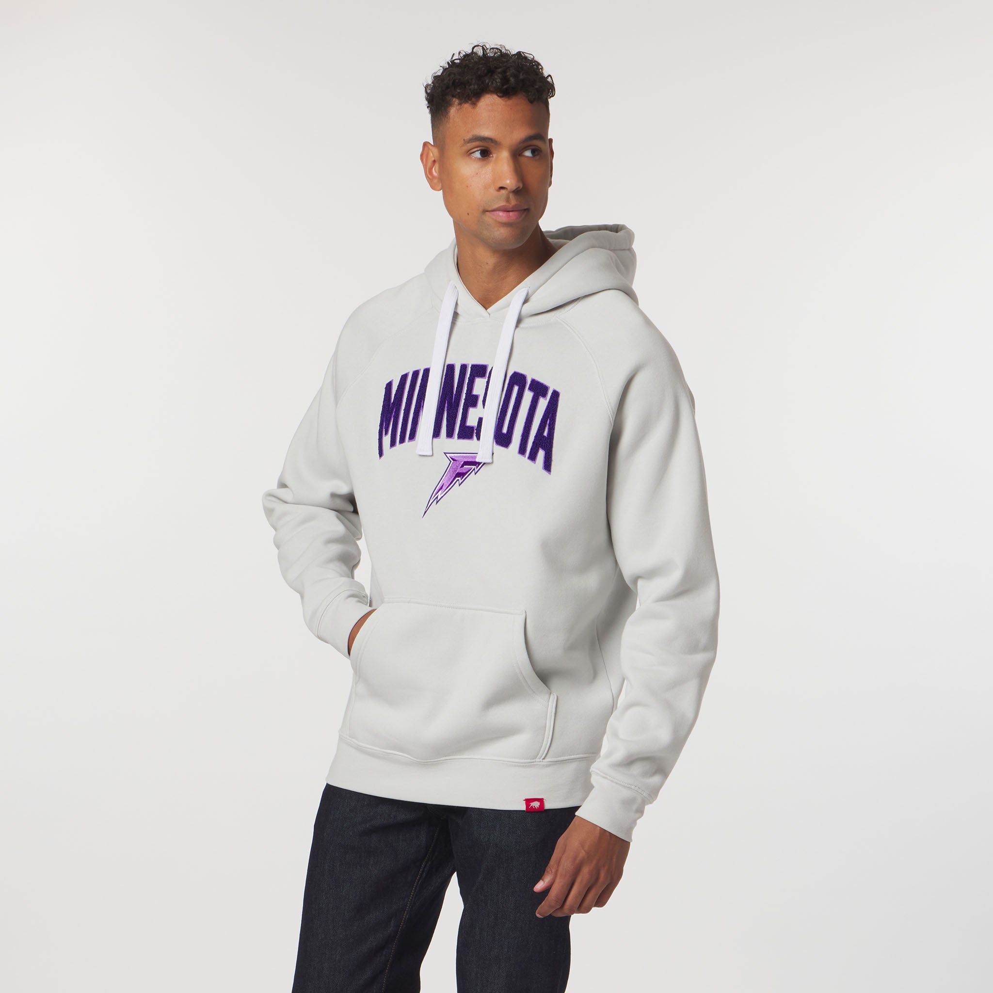 Man wearing a gray hoodie with 'MINNESOTA' printed on it against a white background