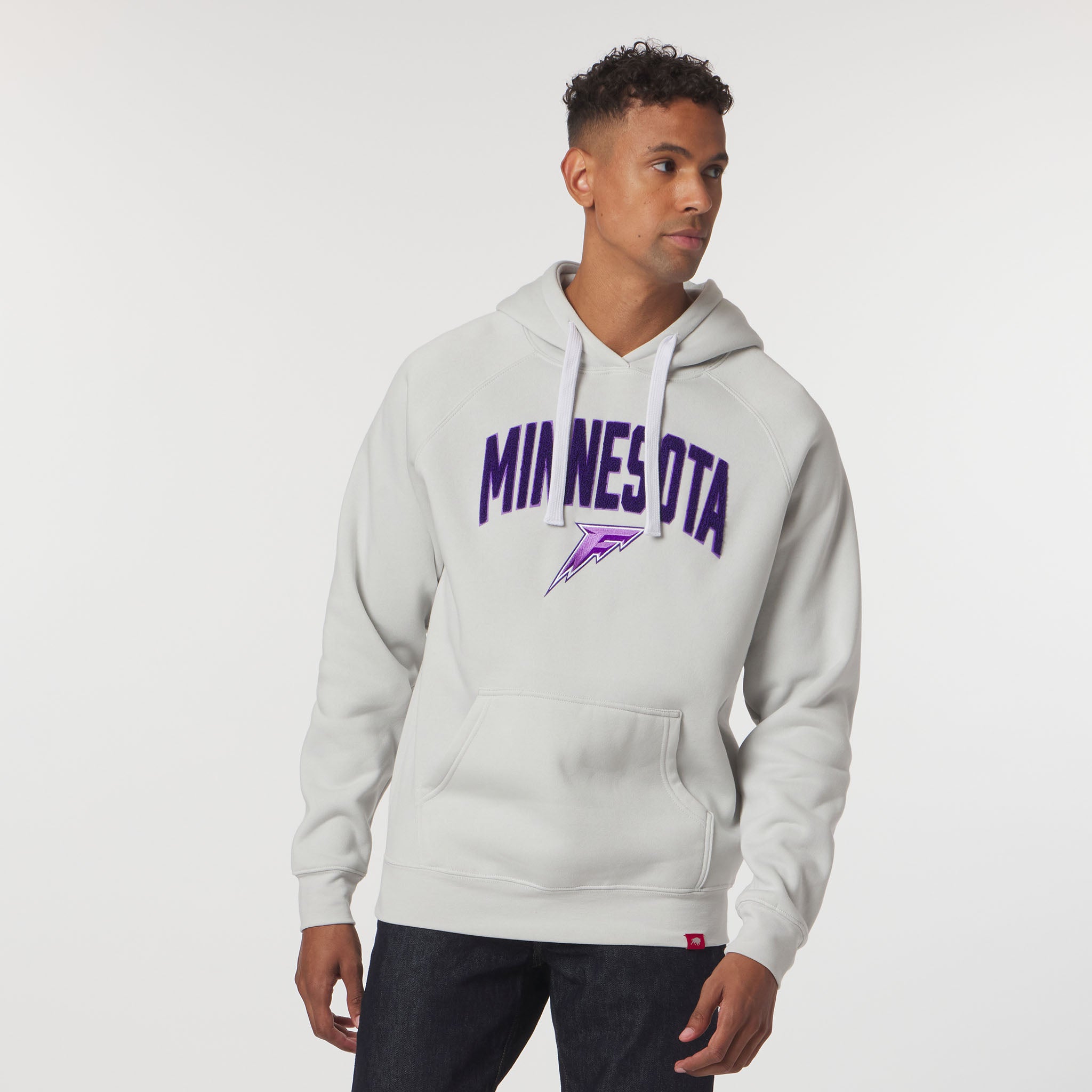 Man wearing a gray hoodie with 'MINNESOTA' printed on it against a white background