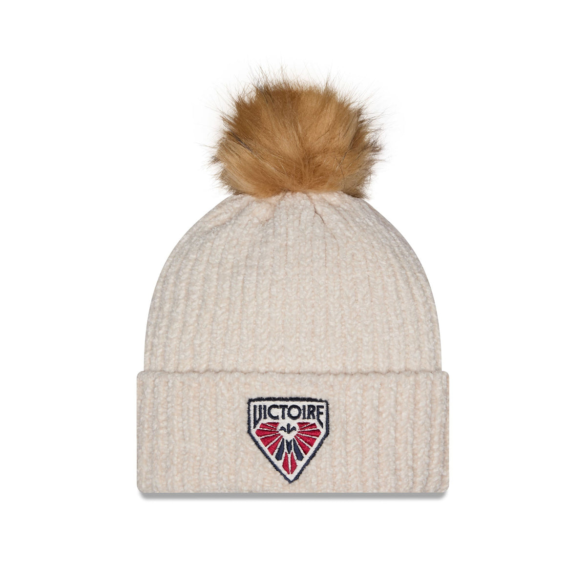 A cream-colored ribbed knit beanie hat with a fluffy tan pom-pom on top and a shield-shaped embroidered 'VICTOIRE' logo patch on the front cuff.