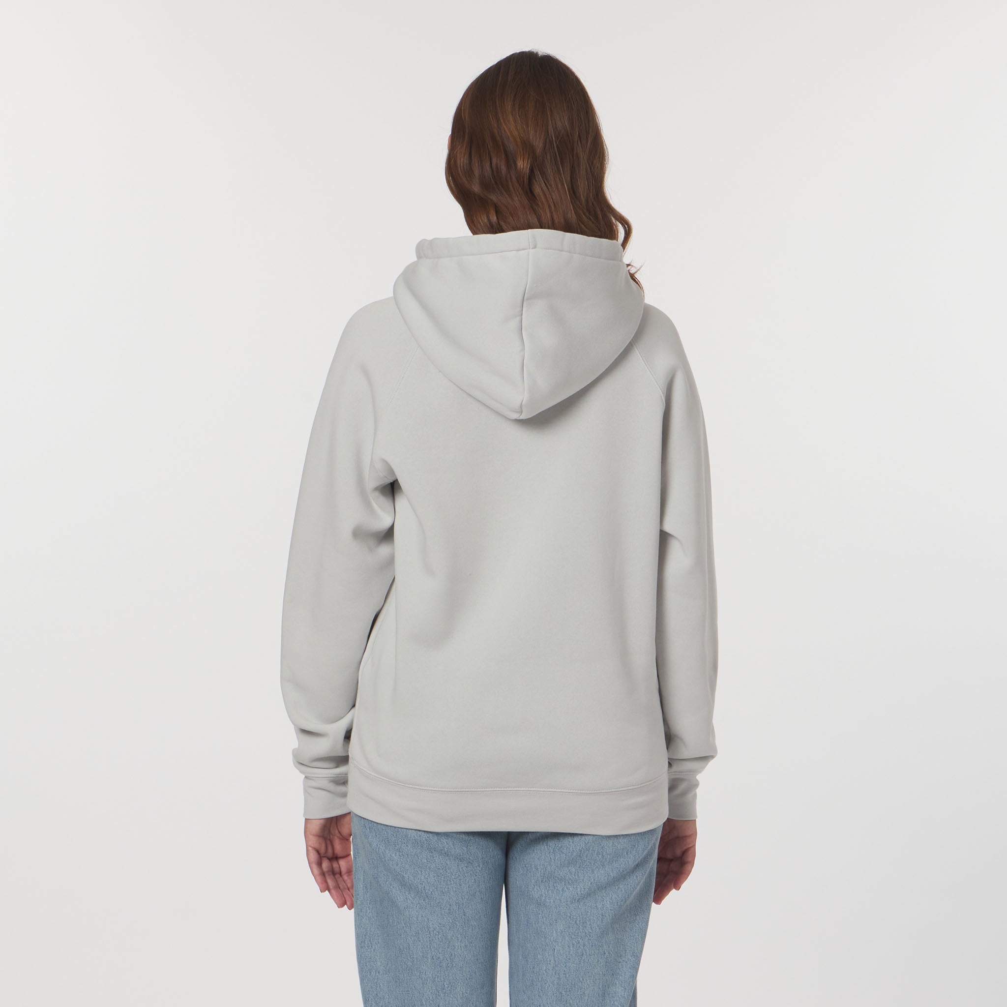 Person wearing a light gray hoodie and light blue jeans on a white background