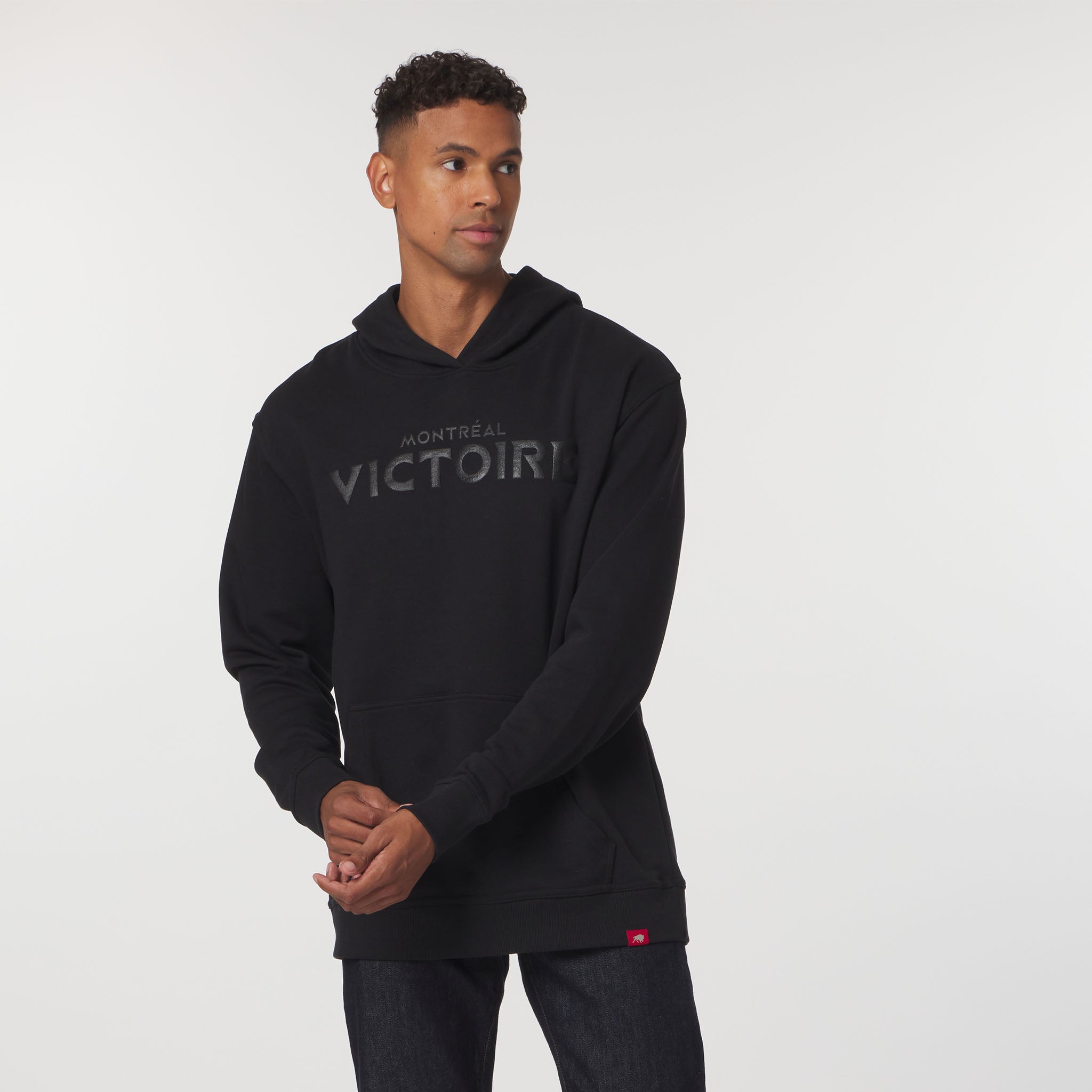 Man wearing a black hoodie with 'Montreal Victoria' text on a white background