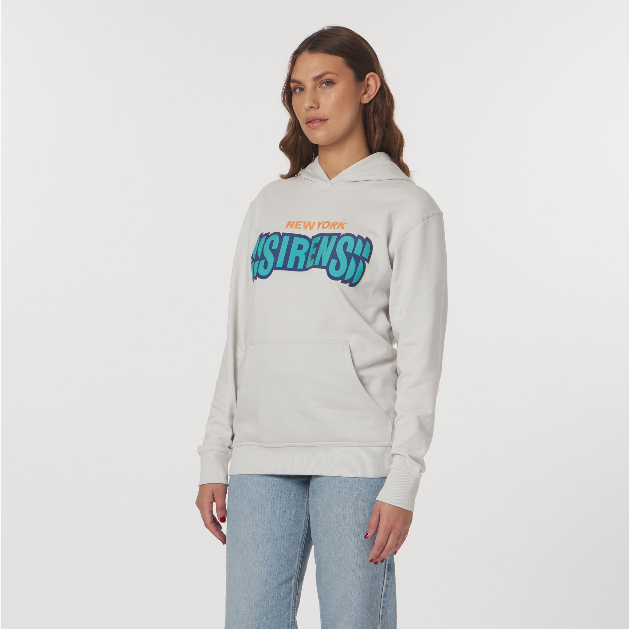 Woman wearing a light gray hoodie with colorful text on a white background