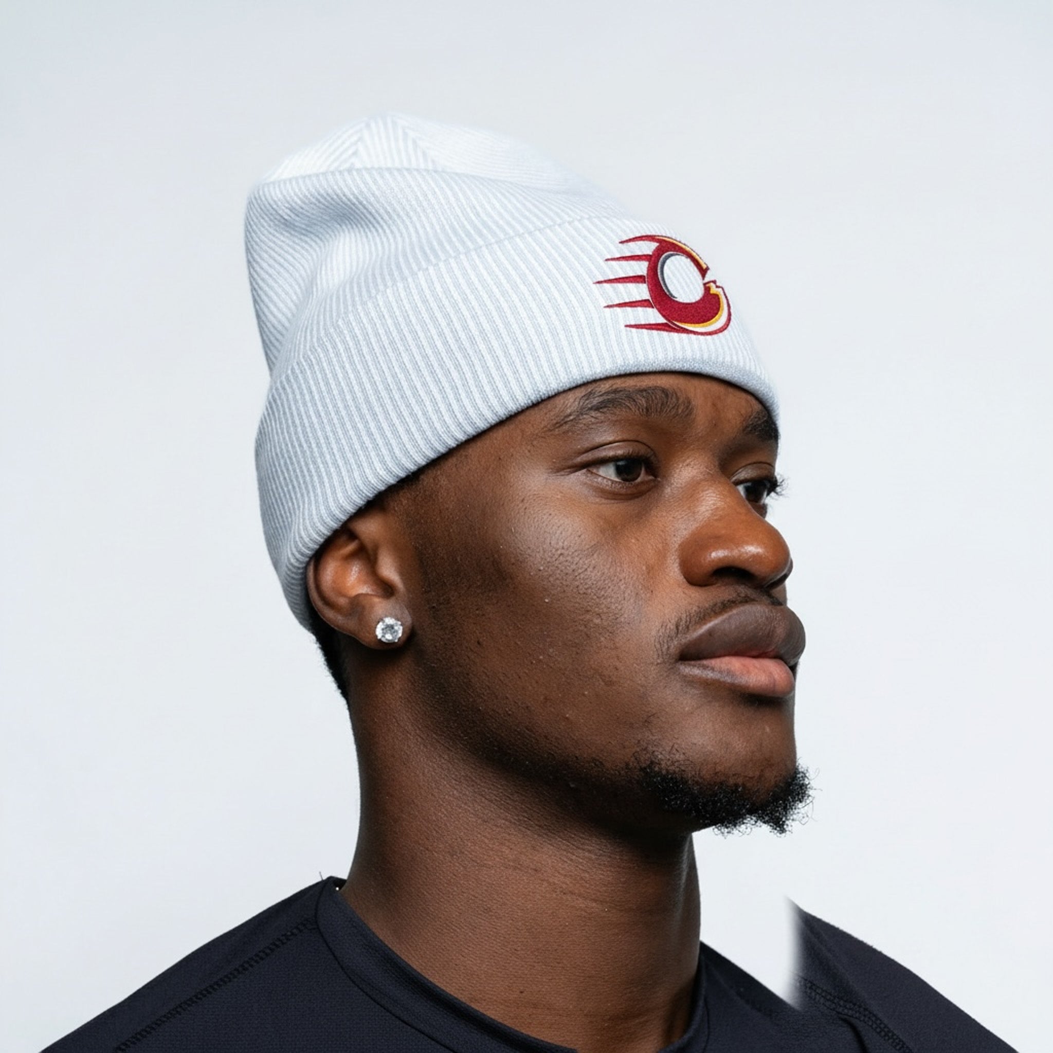 Person wearing a white beanie with a red logo on a plain background