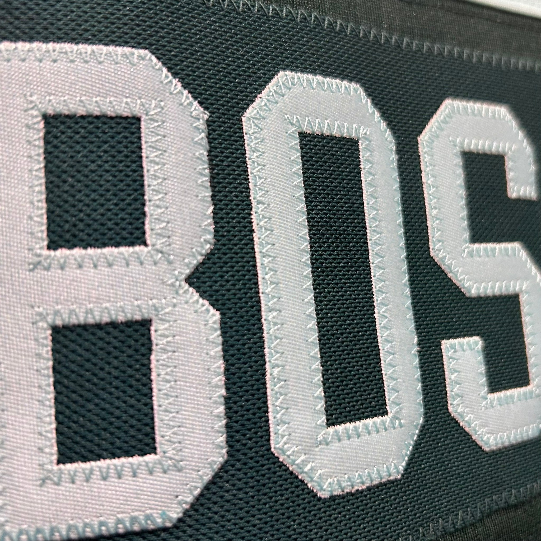 Close-up of a black and gray patch with 'BOSTON' letters.