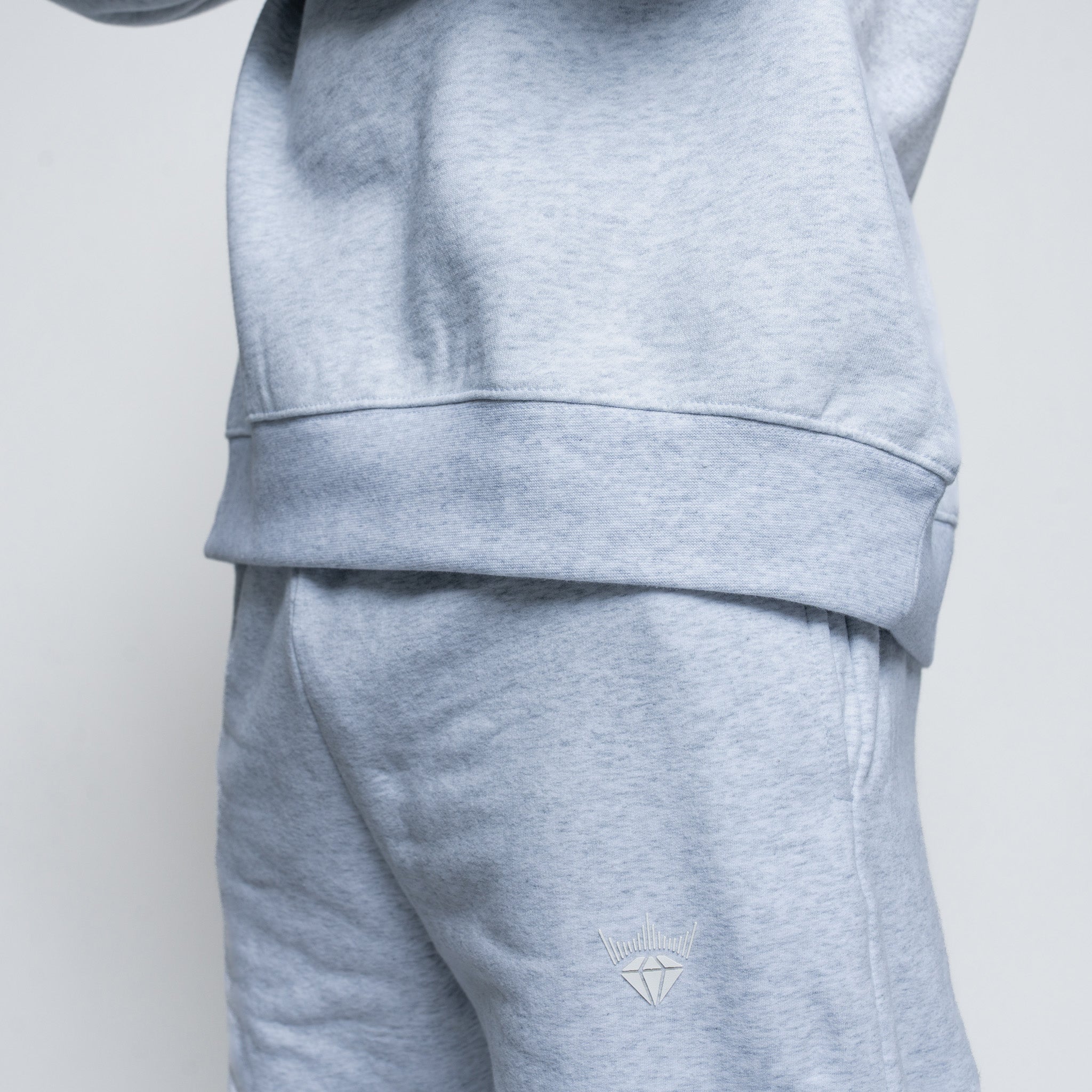 Gray tracksuit with a small logo on the pants against a light gray background