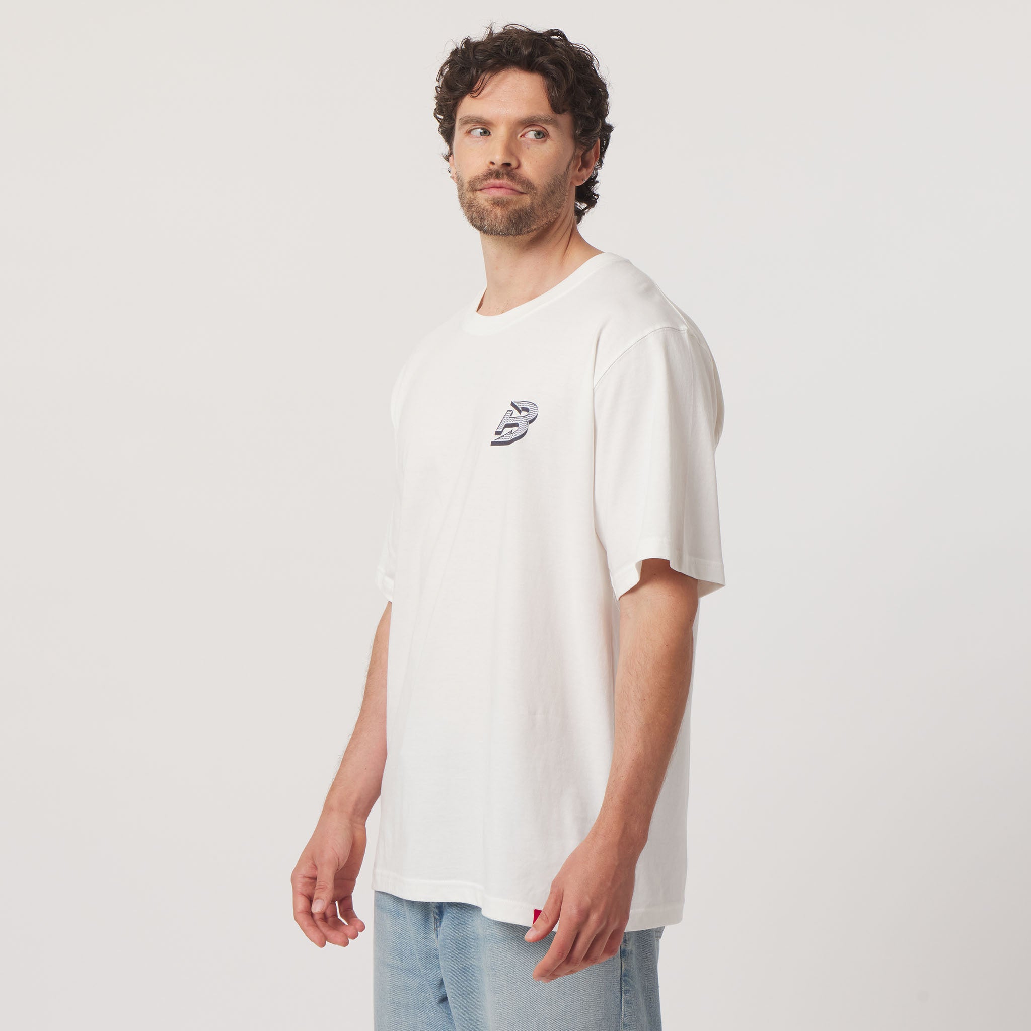 Man wearing a white t-shirt with a logo on a plain background