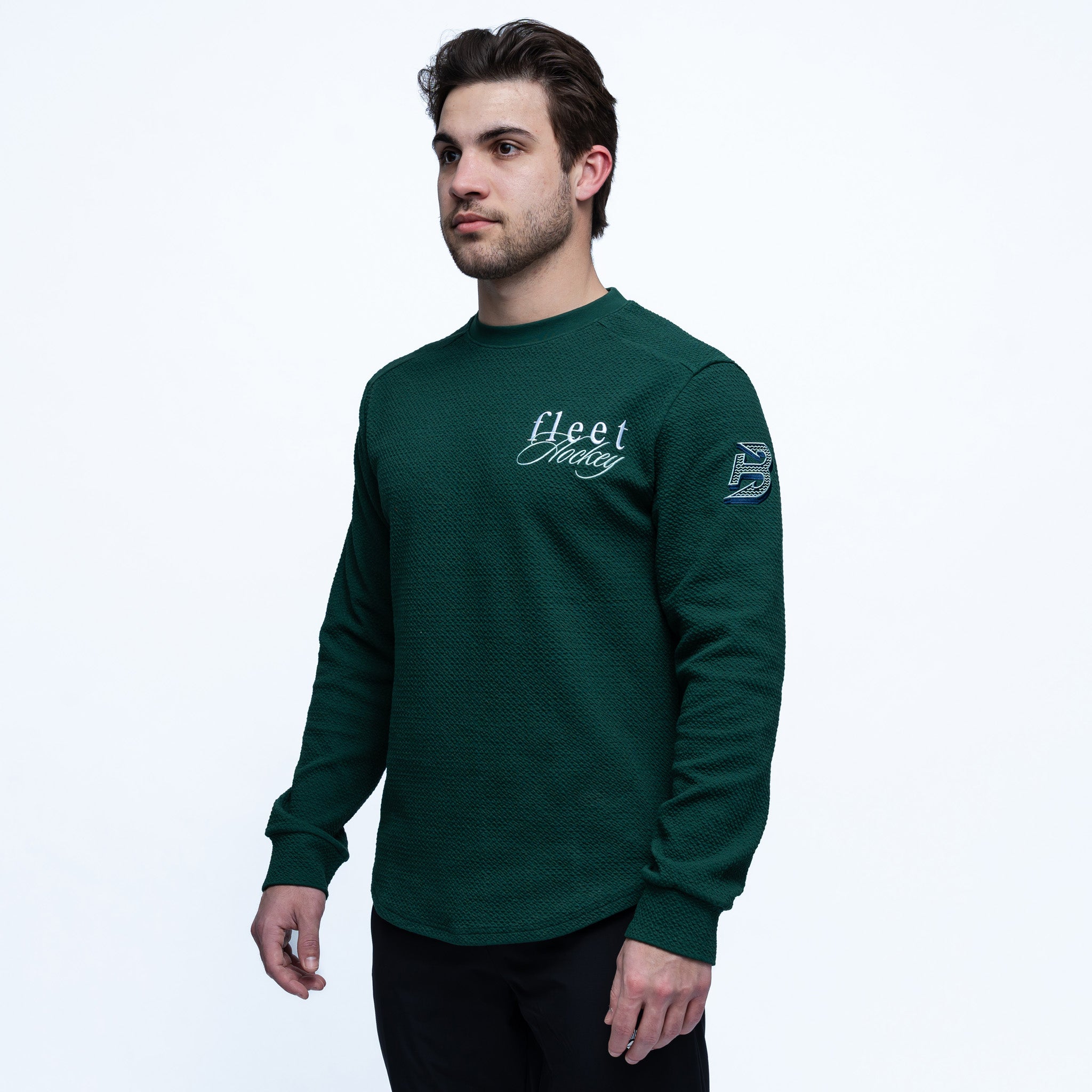 Man wearing a green long-sleeve shirt with 'Fleet' branding on a white background