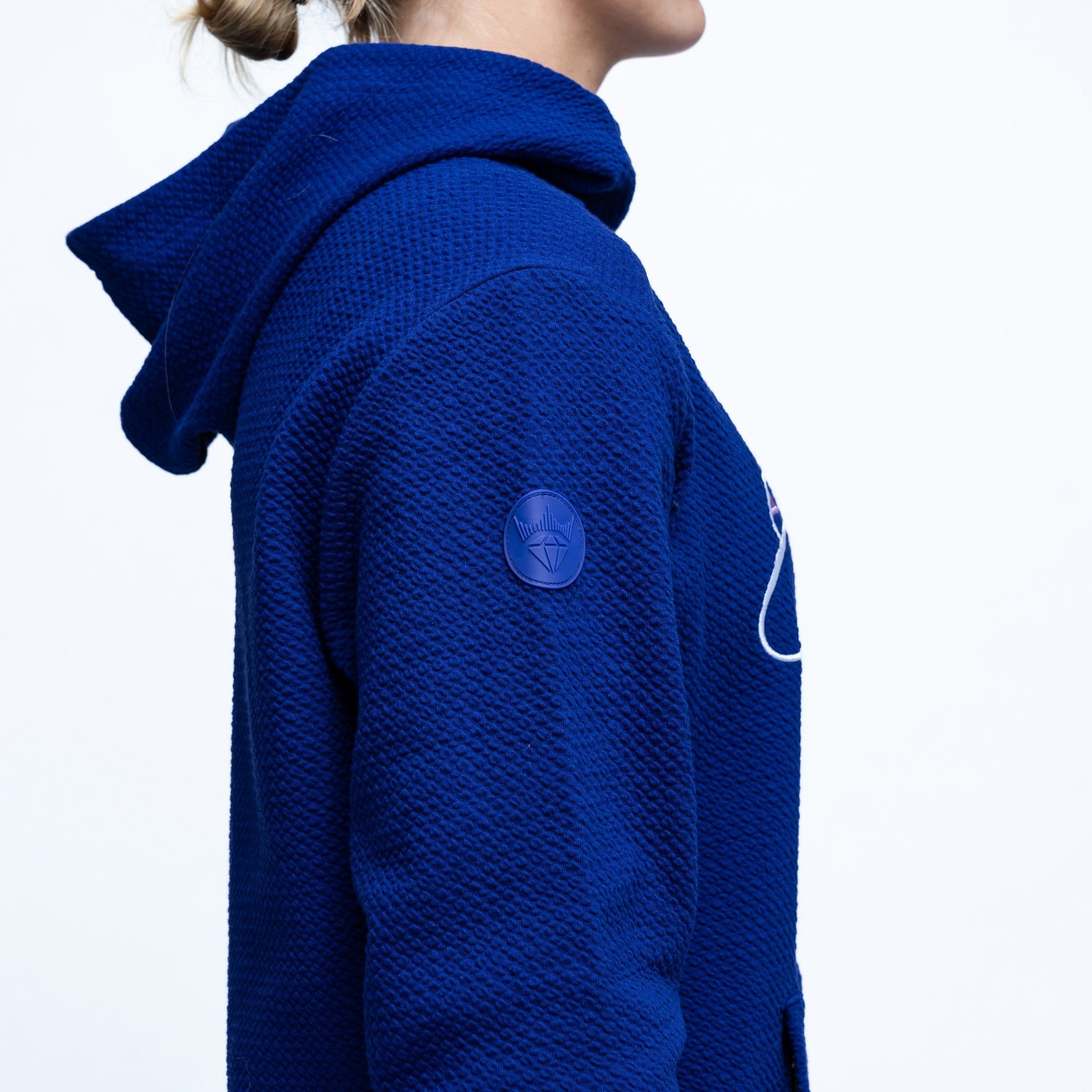 Blue textured hoodie with a brand logo on a white background