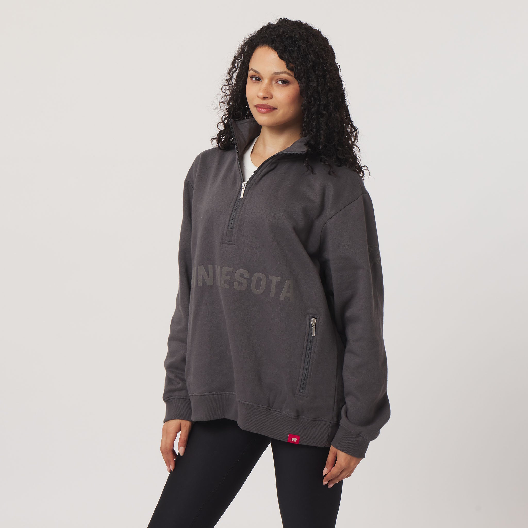 Woman wearing a gray 'MINNESOTA' pullover on a white background