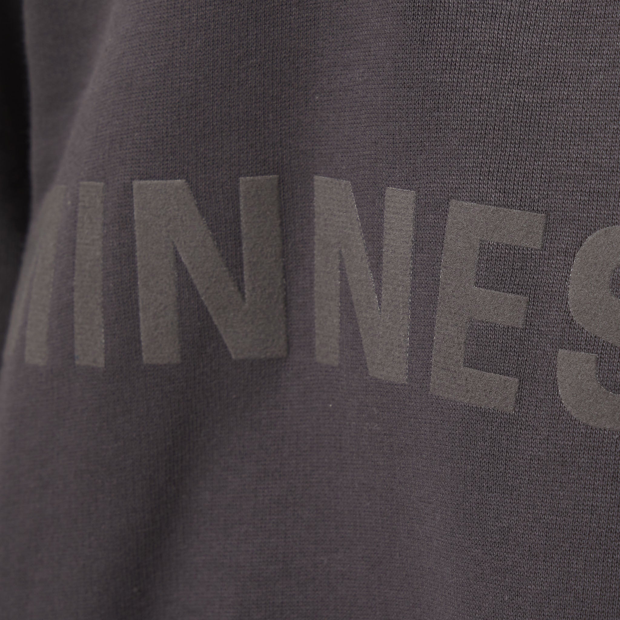 Close-up of a dark gray sweatshirt with 'MINNES' printed on it.