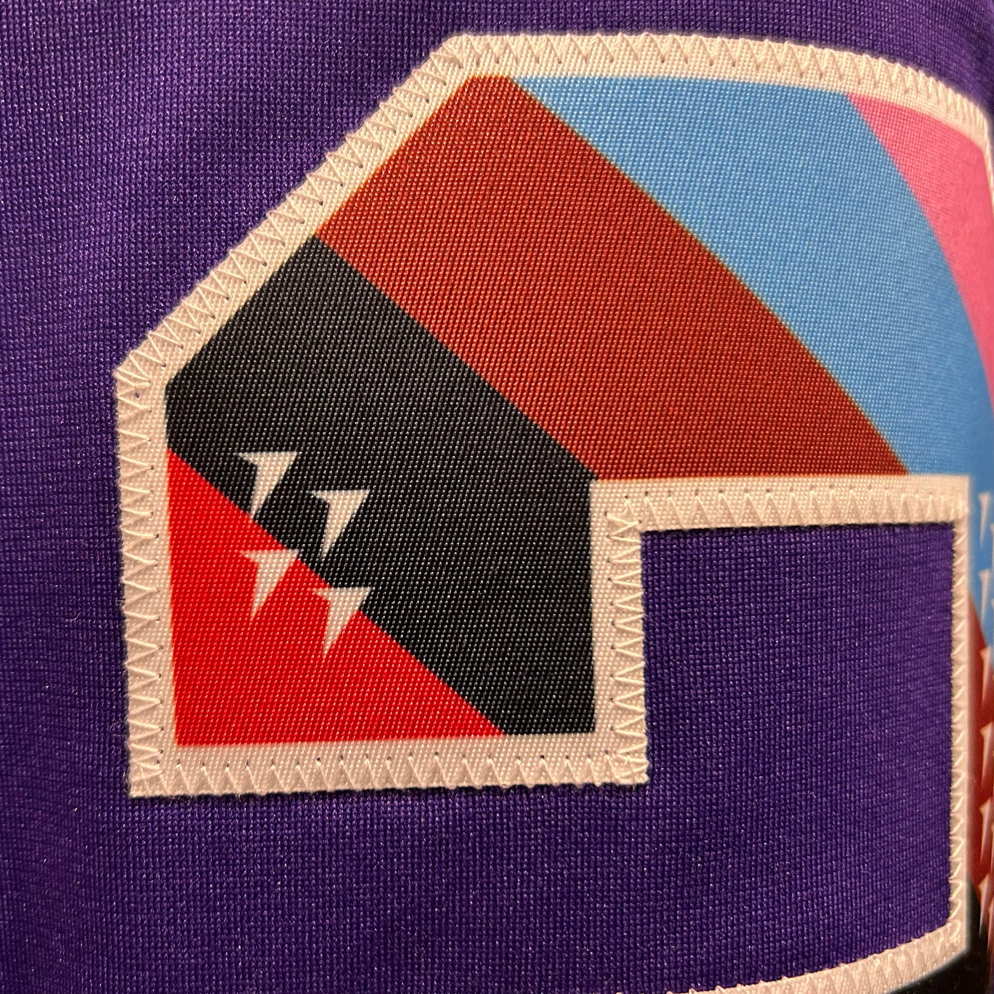 Geometric patch with triangles on a purple background