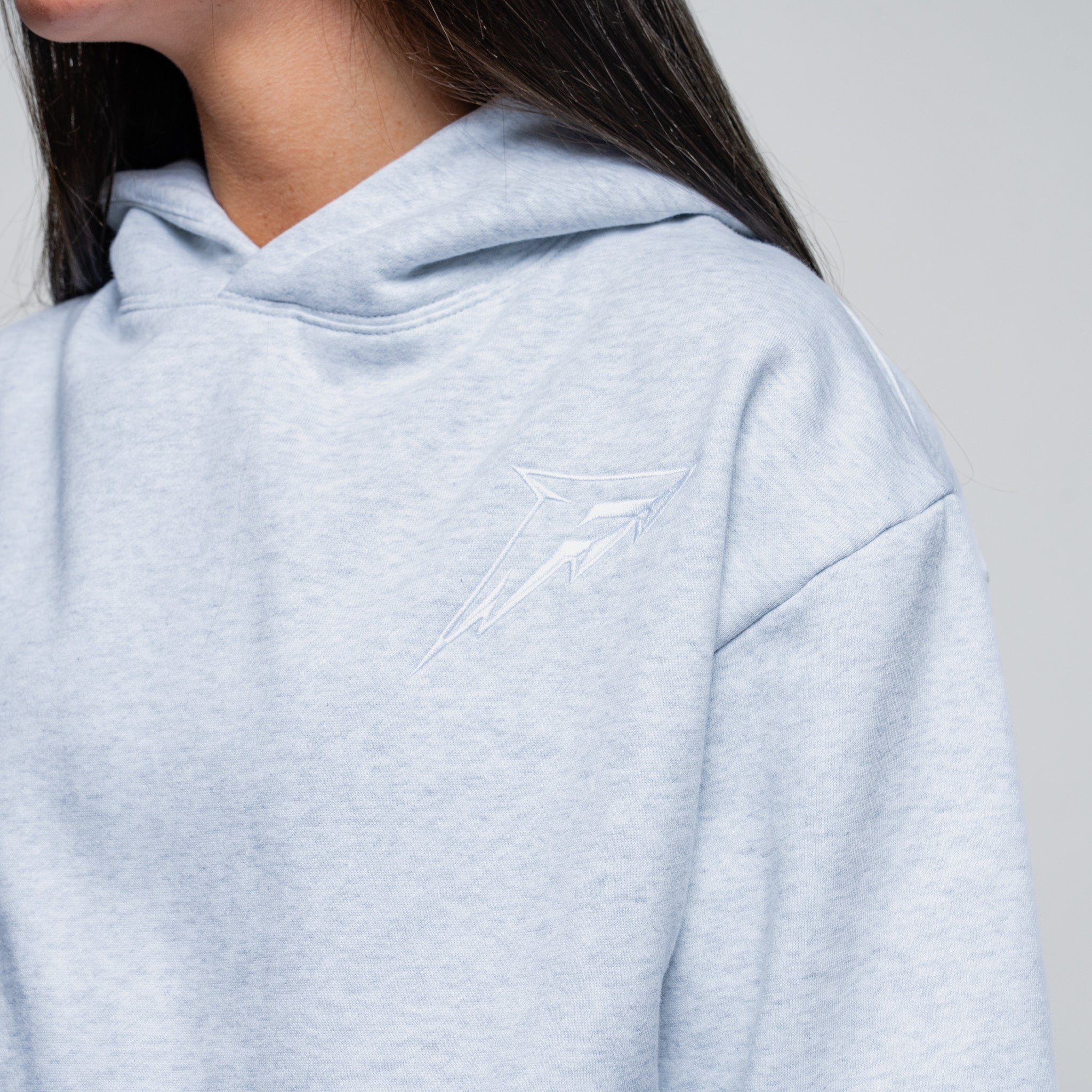 Light gray hoodie worn by a person on a plain background