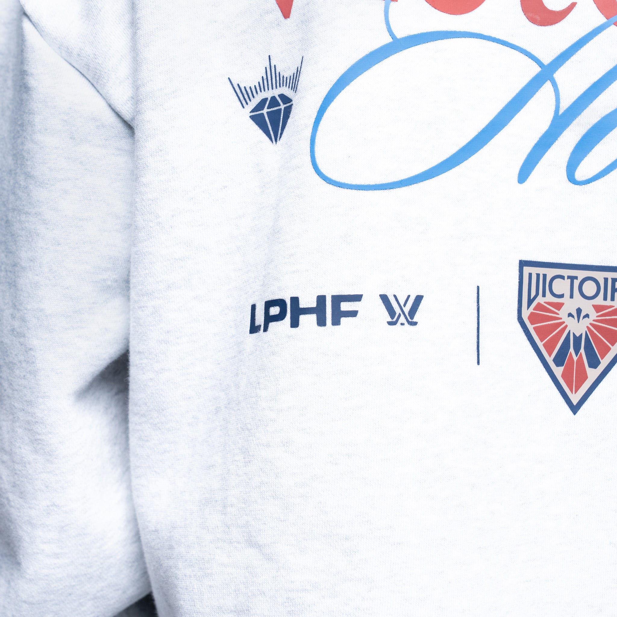 White sweatshirt with logos including 'IPHF' and 'VICTORI', featuring a blue and red design.