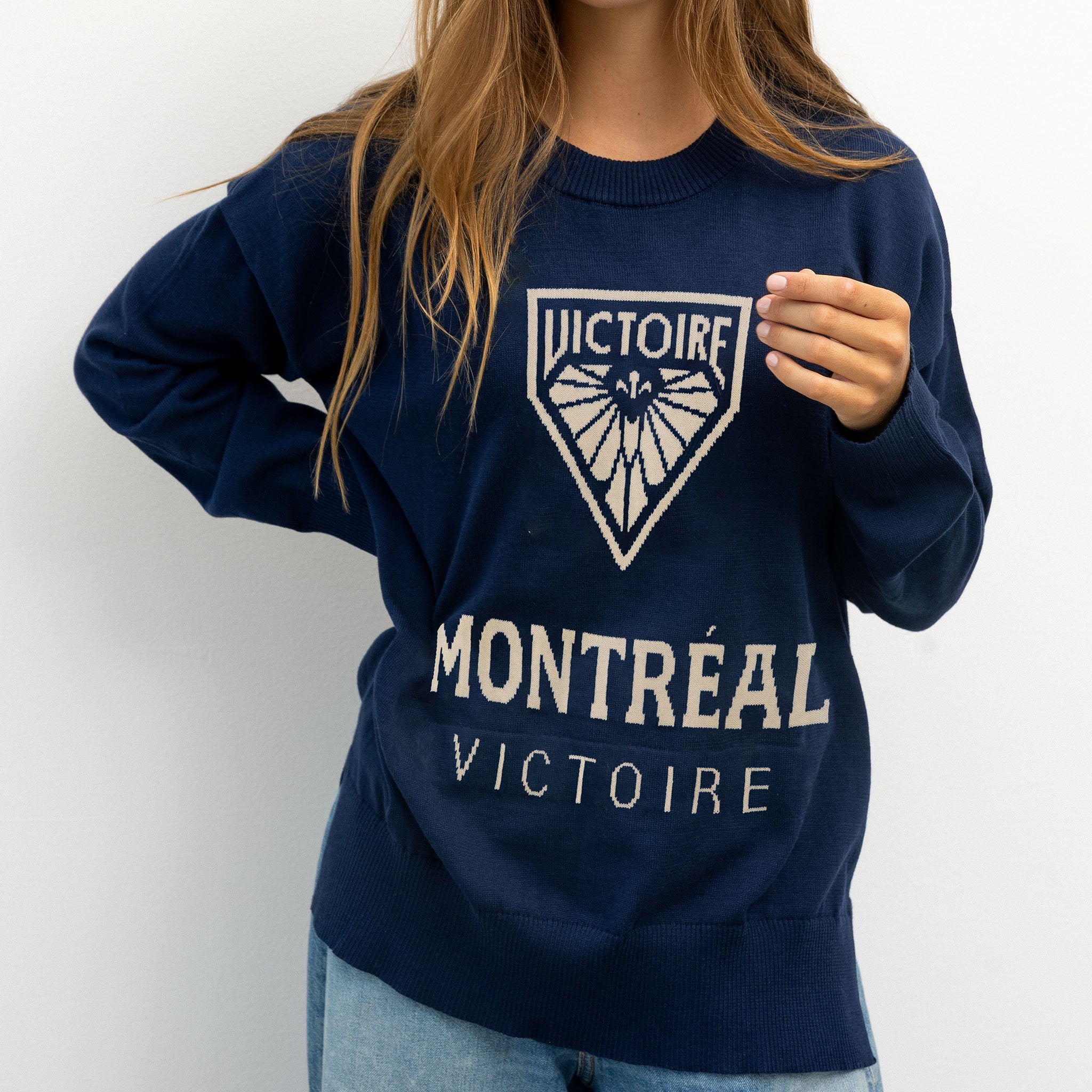 Navy blue sweatshirt with 'Montreal Victoire' text and logo worn by a person on a white background