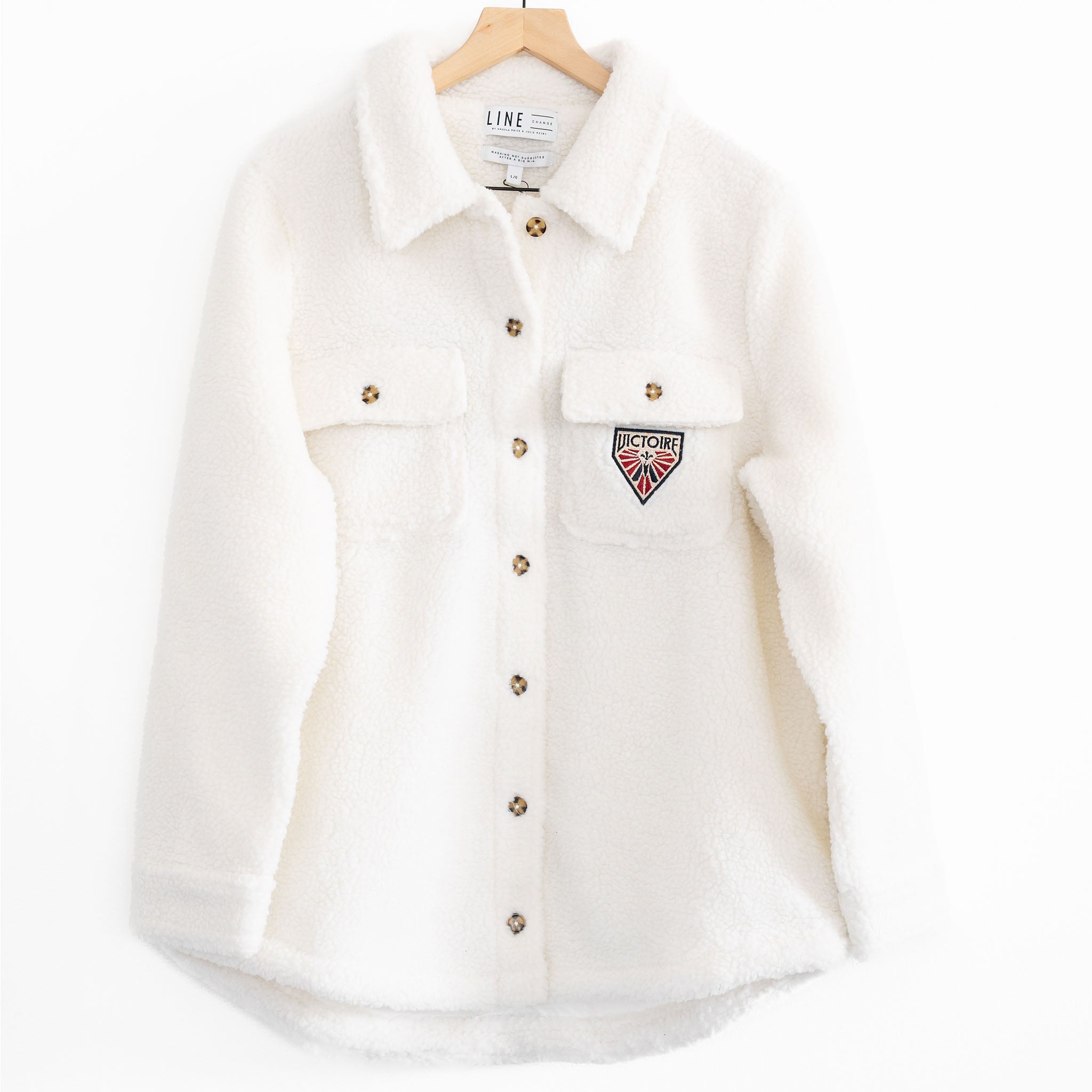 The front of a white sherpa jacket with the Montreal Victoire logo on the pocket