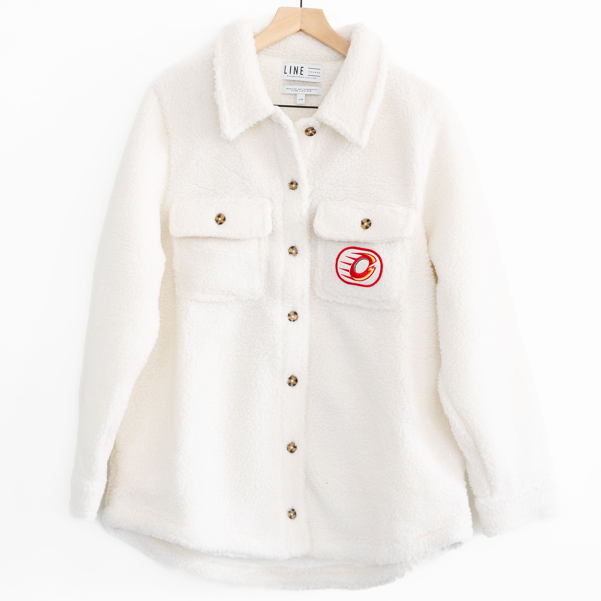 The front of a white sherpa jacket with the Ottawa Charge logo on the pocket