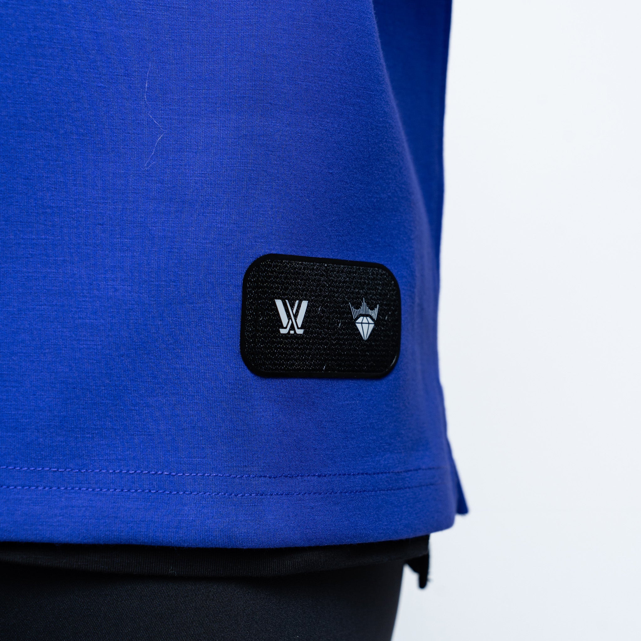 purple sweater with a black patch featuring logos on a white background