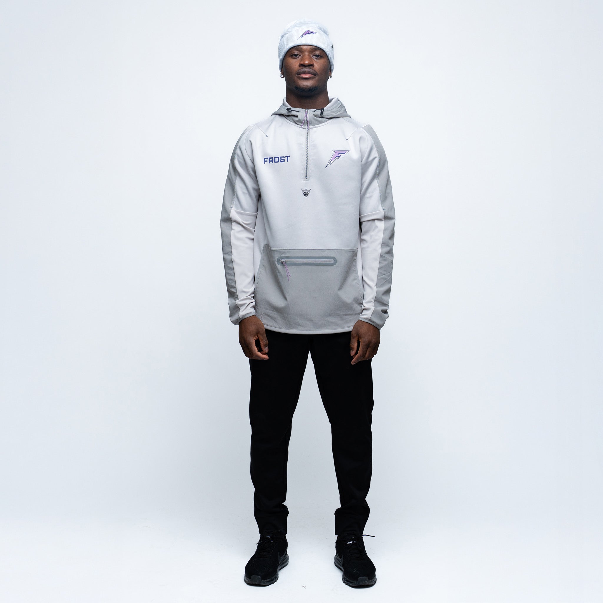 Person wearing a gray hoodie with a brand logo on a white background