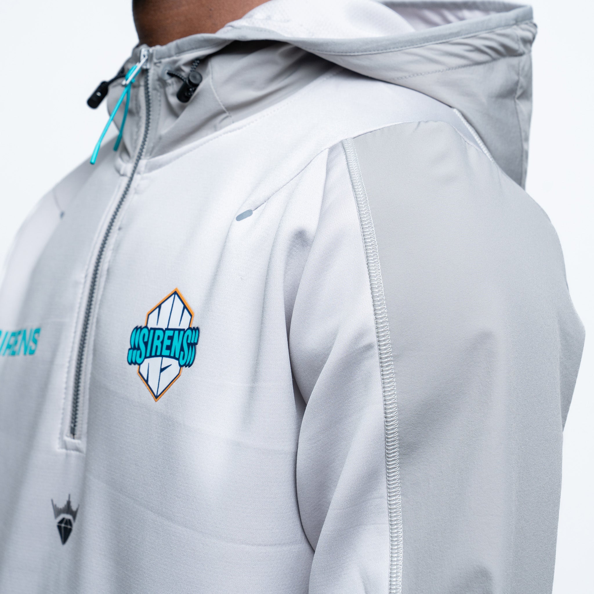 Close-up of a gray jacket with a brand logo on a white background