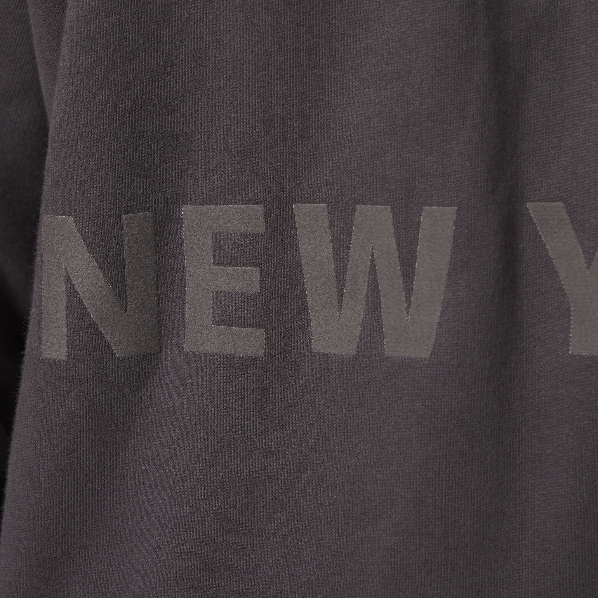 Dark gray sweatshirt with 'NEW YORK' text on a plain background