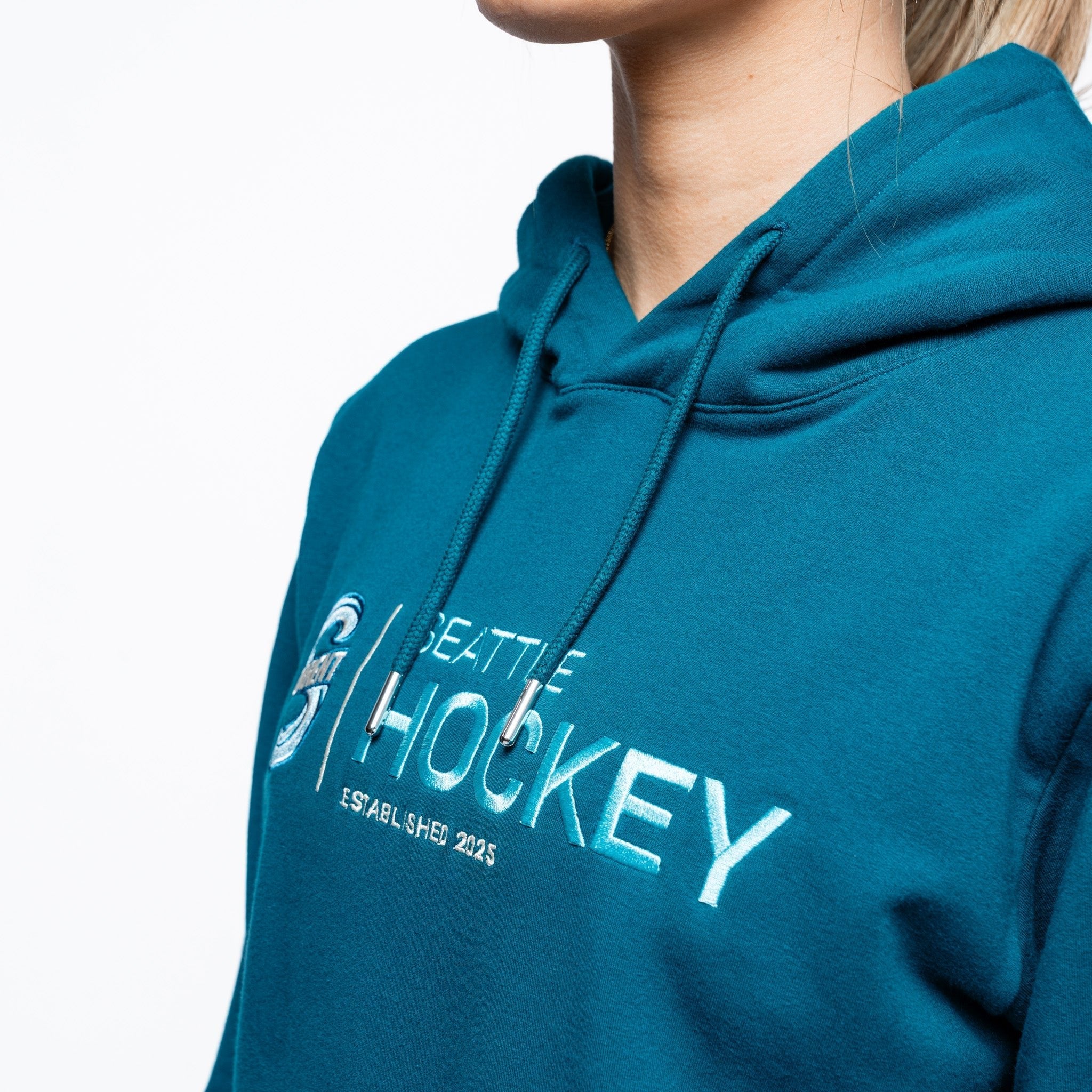 Close up side angle of the embroidery on the green Adult Seattle Torrent Royalty Citymark Cloud Hoodie