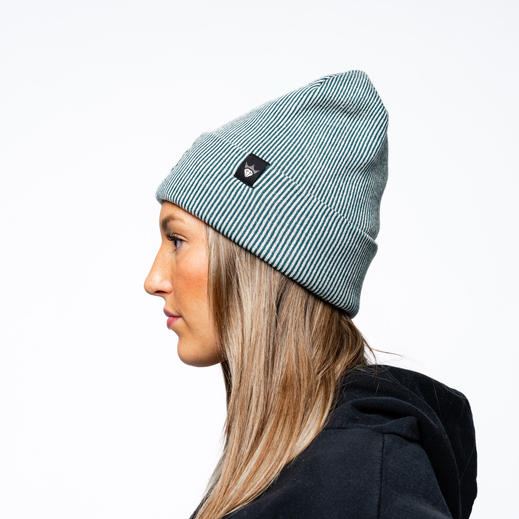 Other side angle of a woman wearing the green Adult Seattle Torrent Royalty Double Knit Beanie
