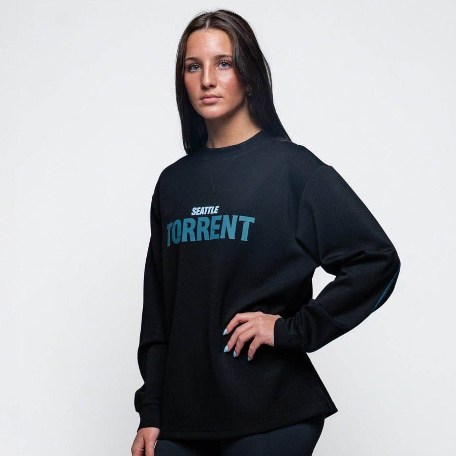 Person wearing a black hoodie with text and black leggings on a white background