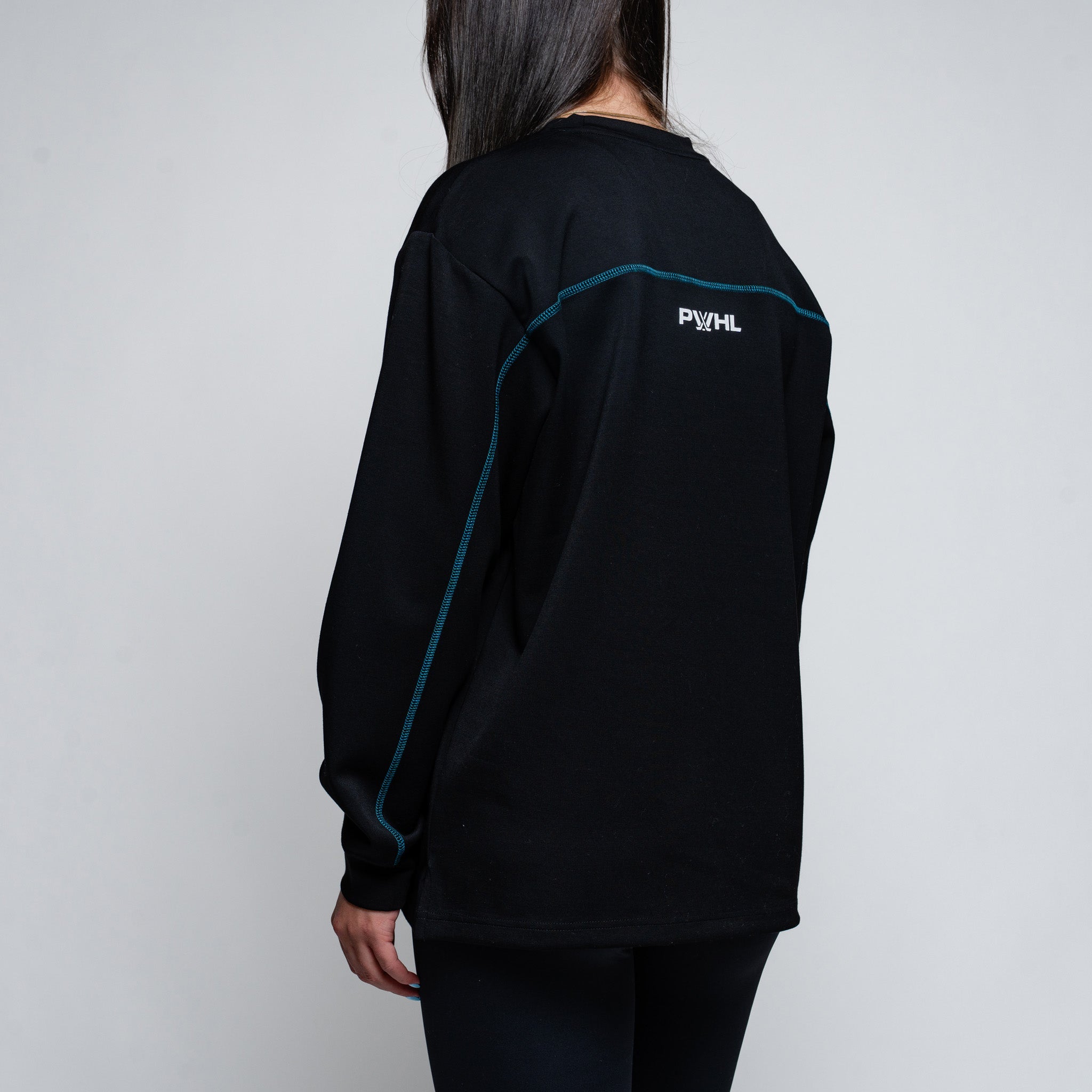 Person wearing a black long-sleeve shirt with a logo on the back against a plain background