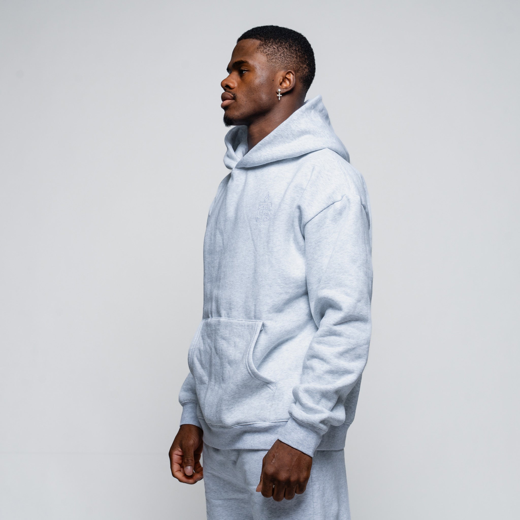 Man wearing a light gray hoodie against a plain background