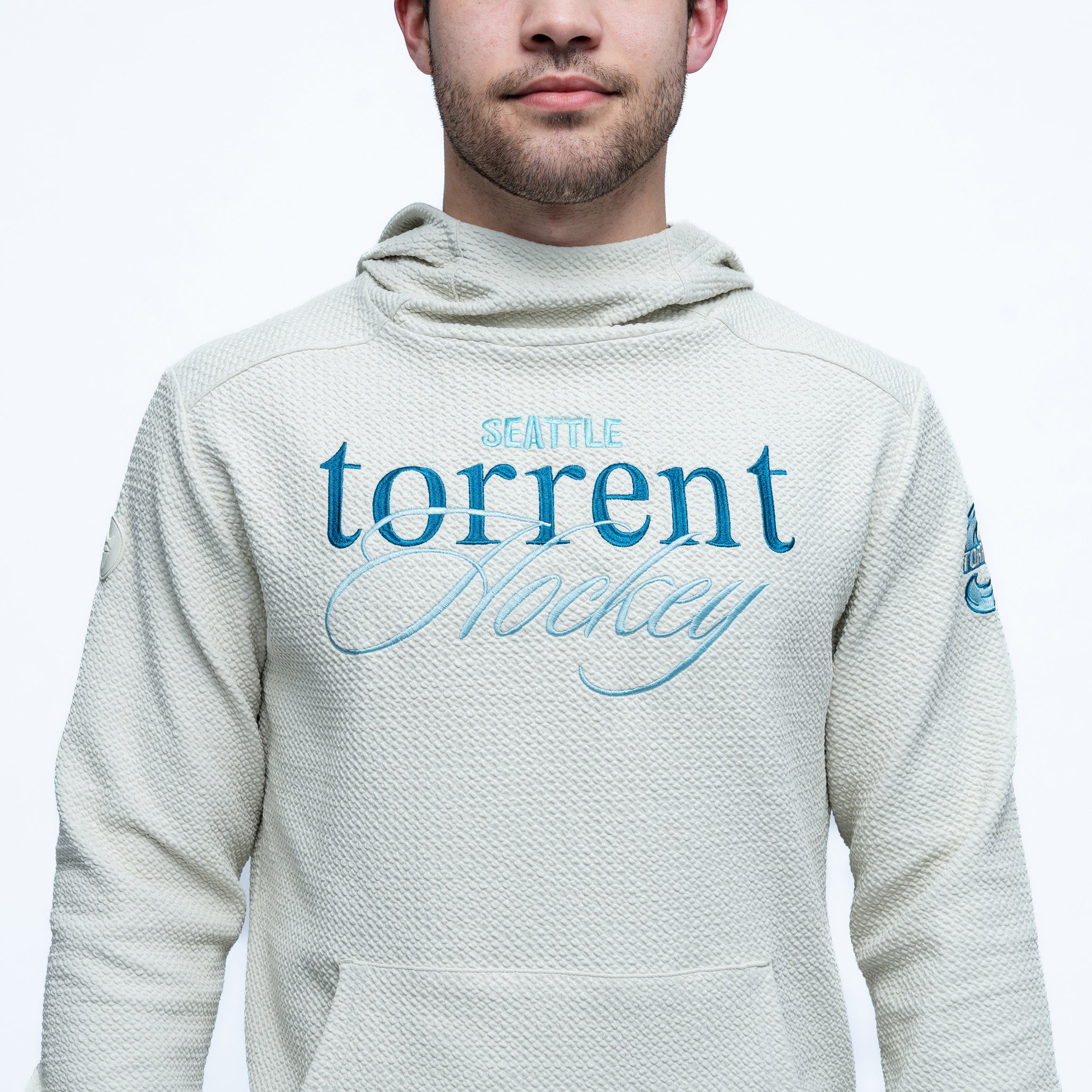 Person wearing a gray hoodie with 'Seattle torrent Hockey' text on a white background