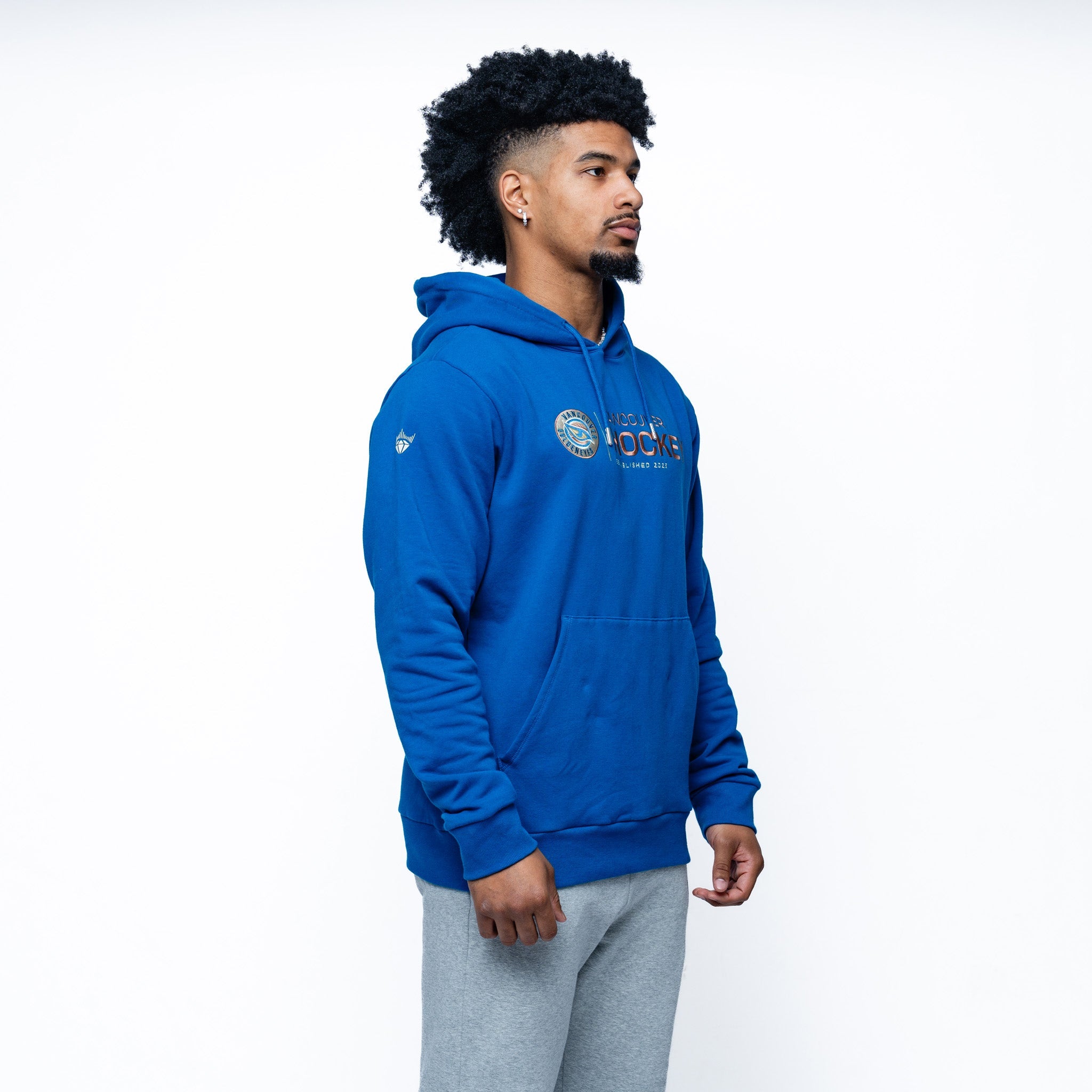 man wearing the blue Adult Vancouver Goldeneyes Royalty Citymark Cloud Hoodie side angle