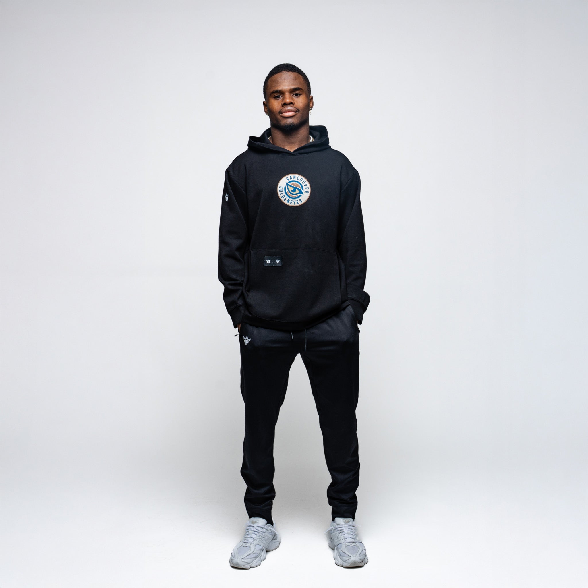 Person wearing a black hoodie with a logo on a white background