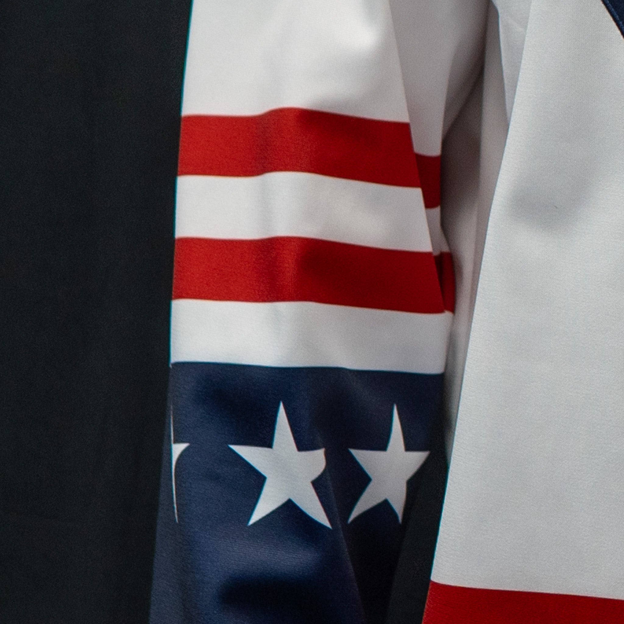 Close-up of a sublimated sleeve with a white, red and navy design featuring white stars on the navy band, and two red bands above.