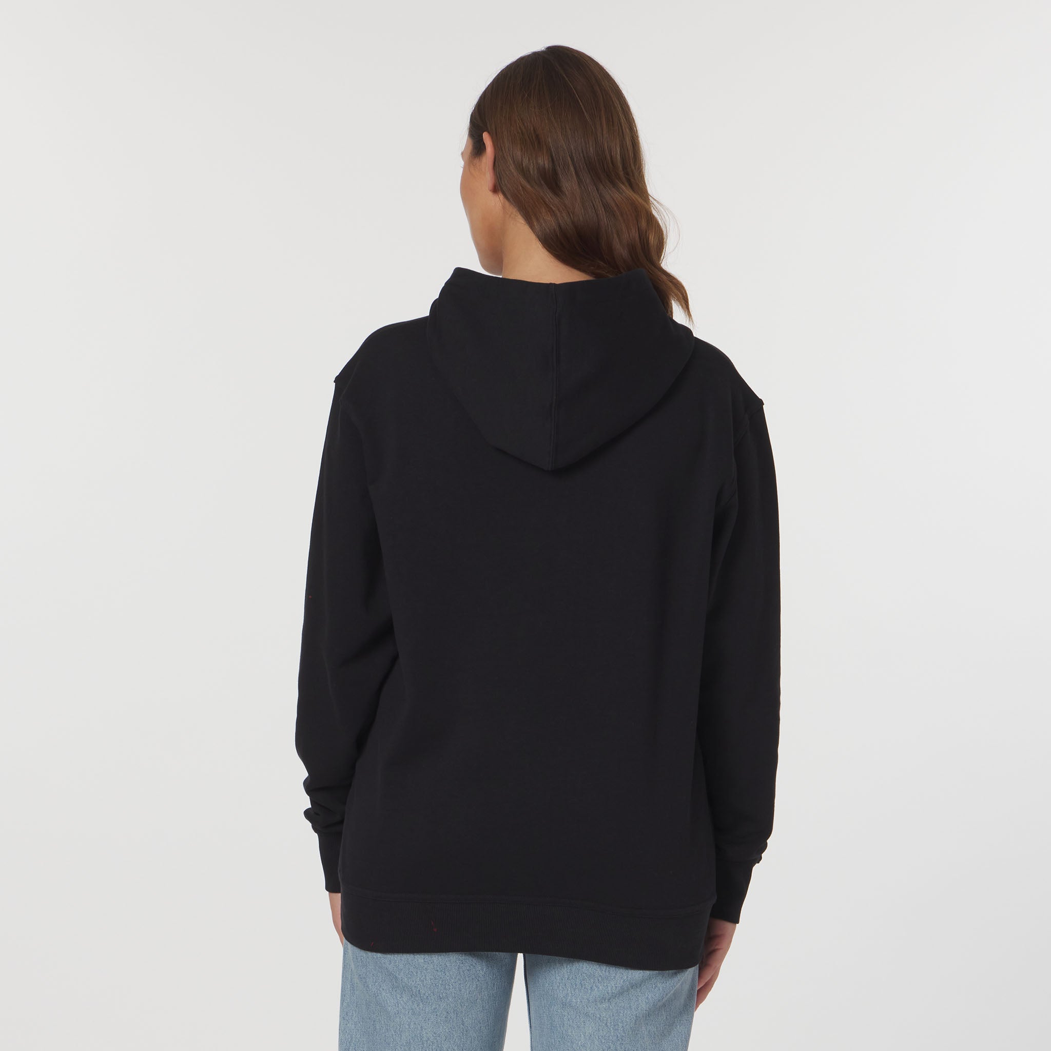 Person wearing a black hoodie from behind on a light gray background