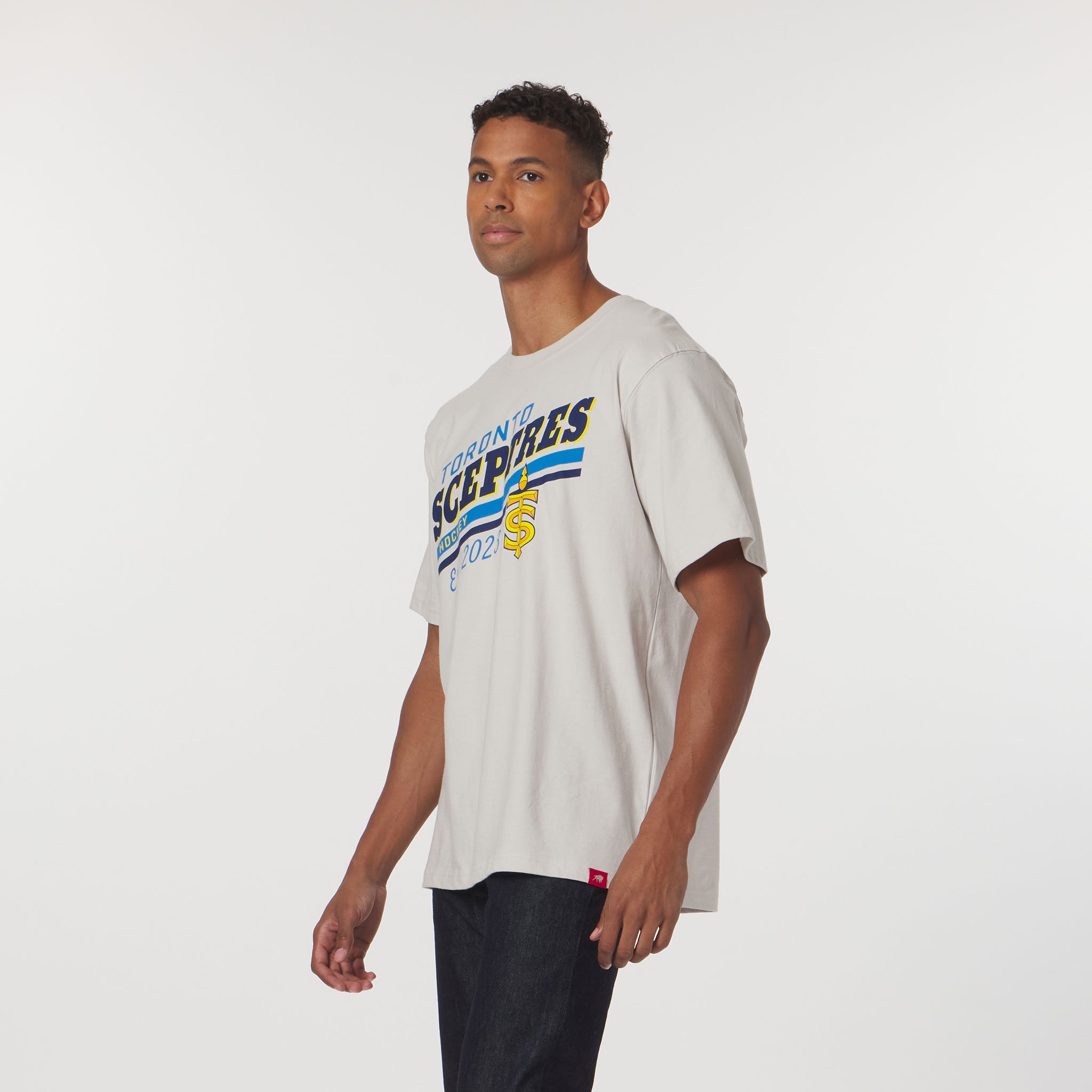 Man wearing a white t-shirt with colorful text on a plain background