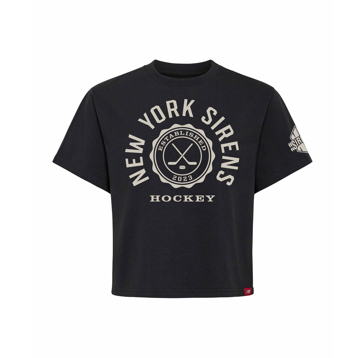 Front of a black short sleeve shirt. 'NEW YORK SIRENS' is written in a white arch of text around a circular emblem with crossed hockey sticks and 'ESTABLISHED 2023' inside with 'HOCKEY' below it. A white mono-color New York Sirens logo is on the left sleeve.