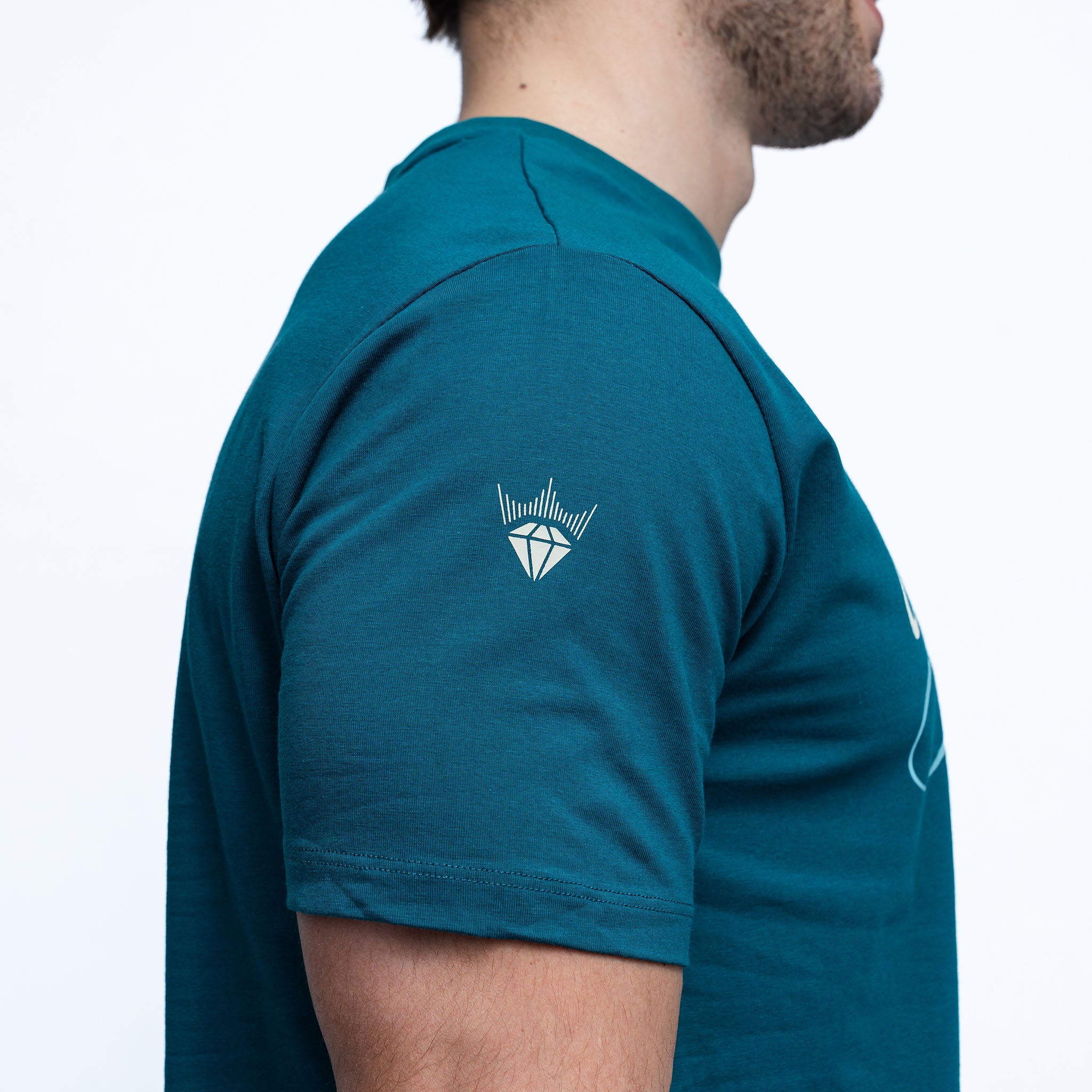 Teal polo shirt with a logo on the chest worn by a person against a white background