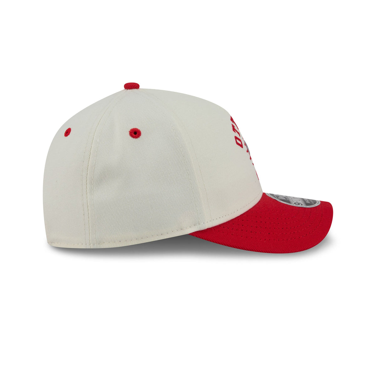 A structured baseball cap in off-white with a red visor, red eyelets, and red embroidered lettering on the side, shown on a clean white background.