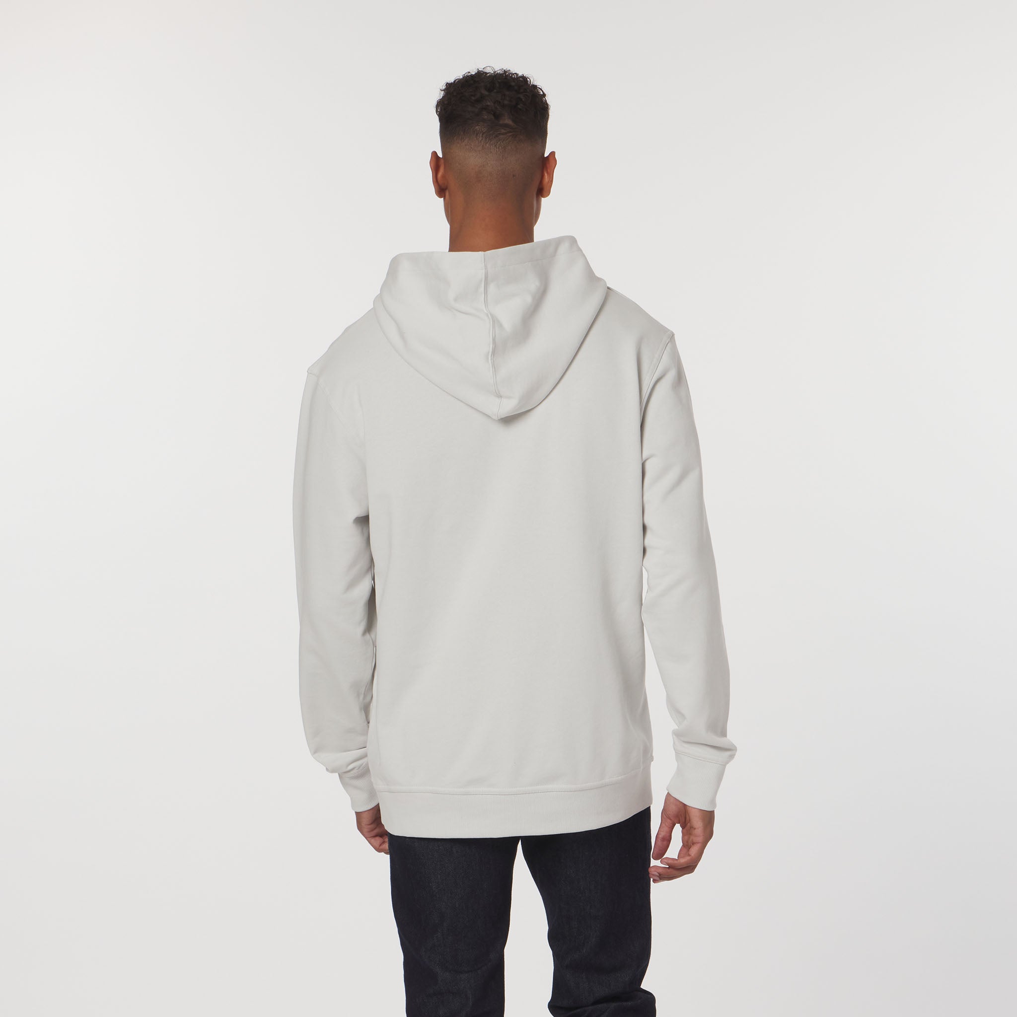 Person wearing a light gray hoodie on a white background