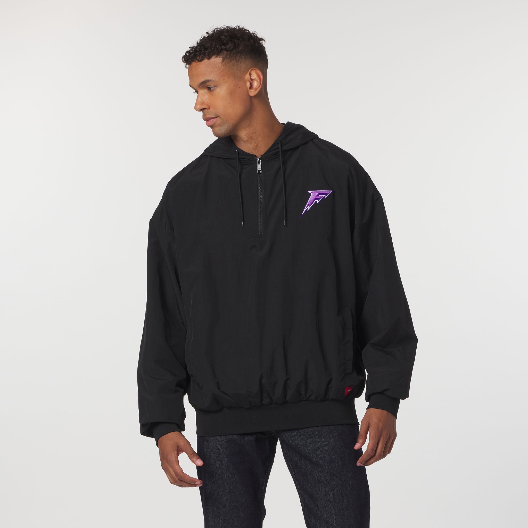 Person wearing a black hoodie with a purple logo on a white background
