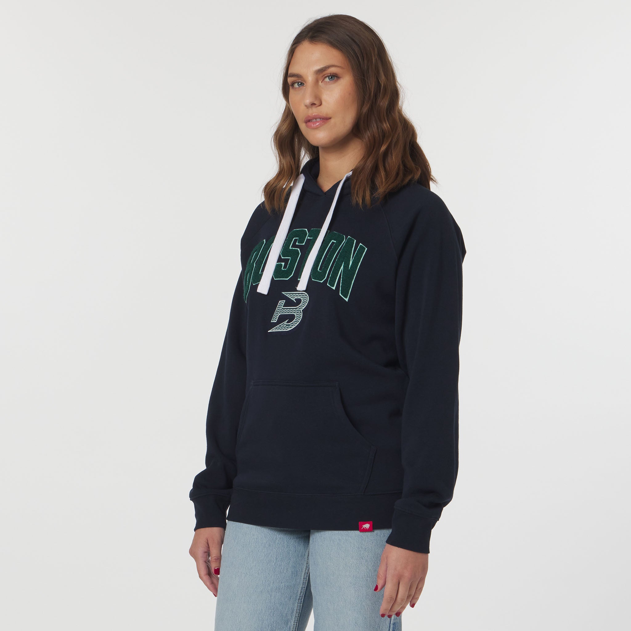 Woman wearing a navy hoodie with green and white text on a plain background
