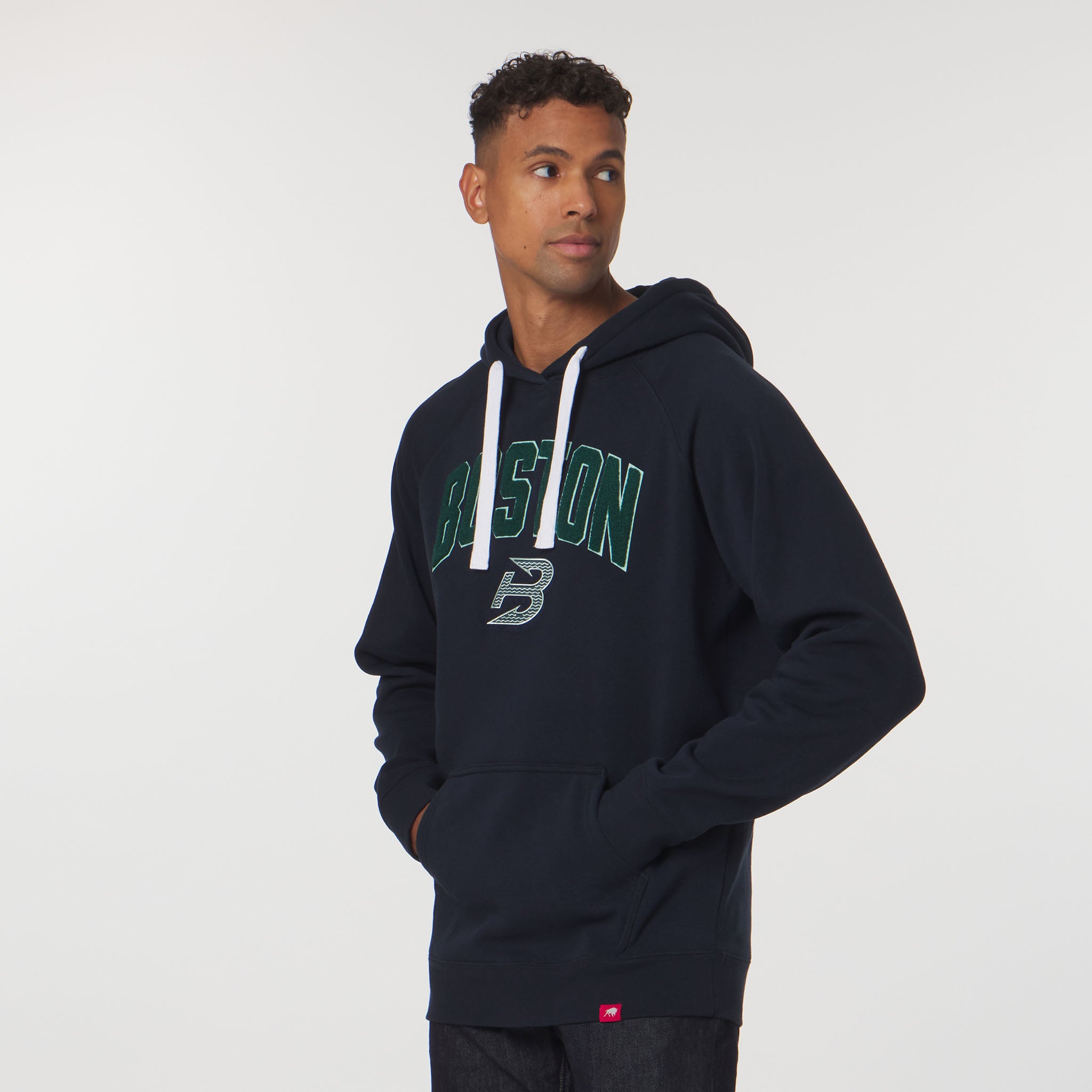Man wearing a navy hoodie with 'Boston' printed on it against a white background