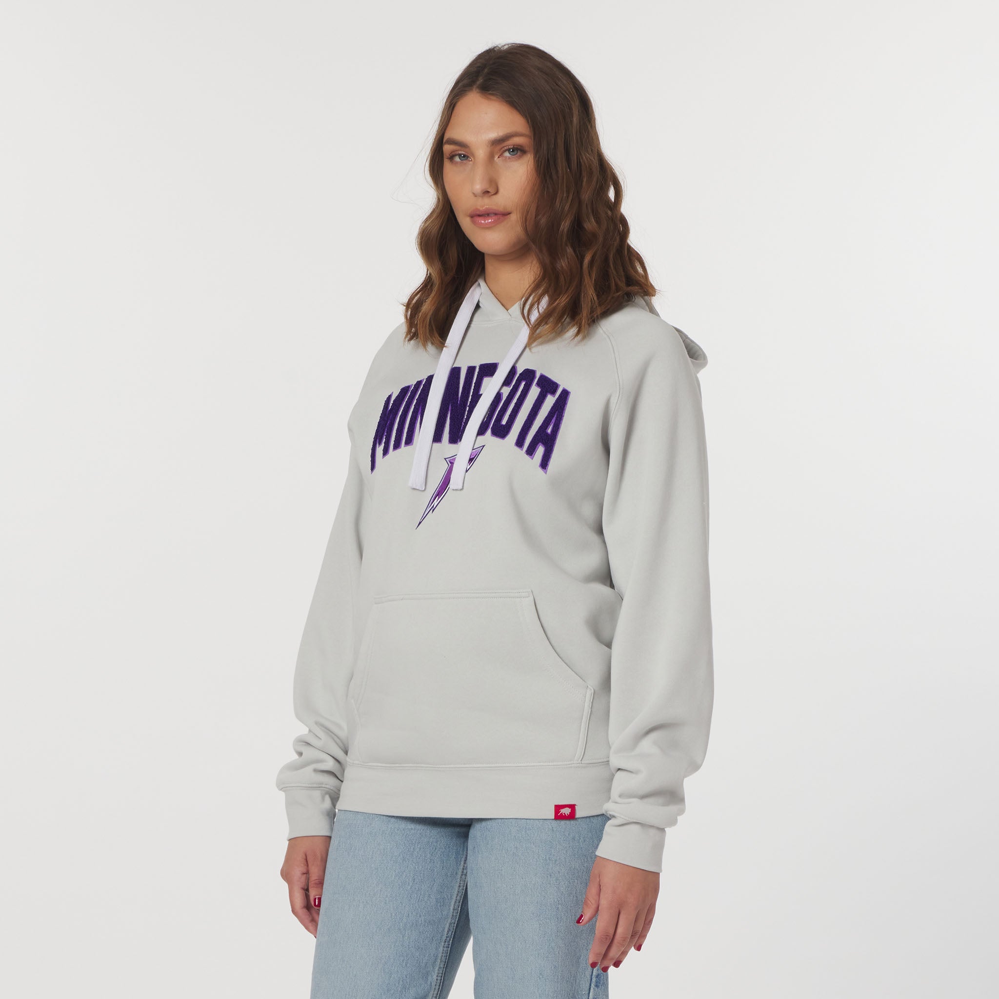 Woman wearing a gray hoodie with purple text on a white background