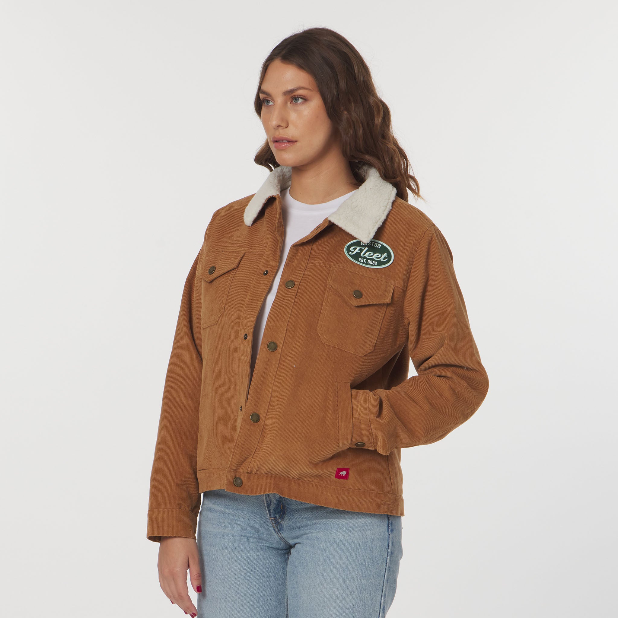 Woman wearing a brown jacket with a brand logo on a white background